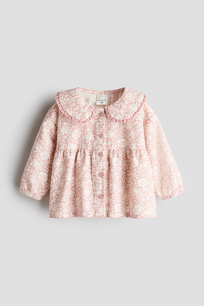 This front-facing view showcases a pink and white floral-patterned corduroy blouse, featuring a lace-trimmed Peter Pan collar and matching buttons down the front. The design features a gathered seam above the waist for added volume, along with long sleeves with elasticated cuffs. - 1