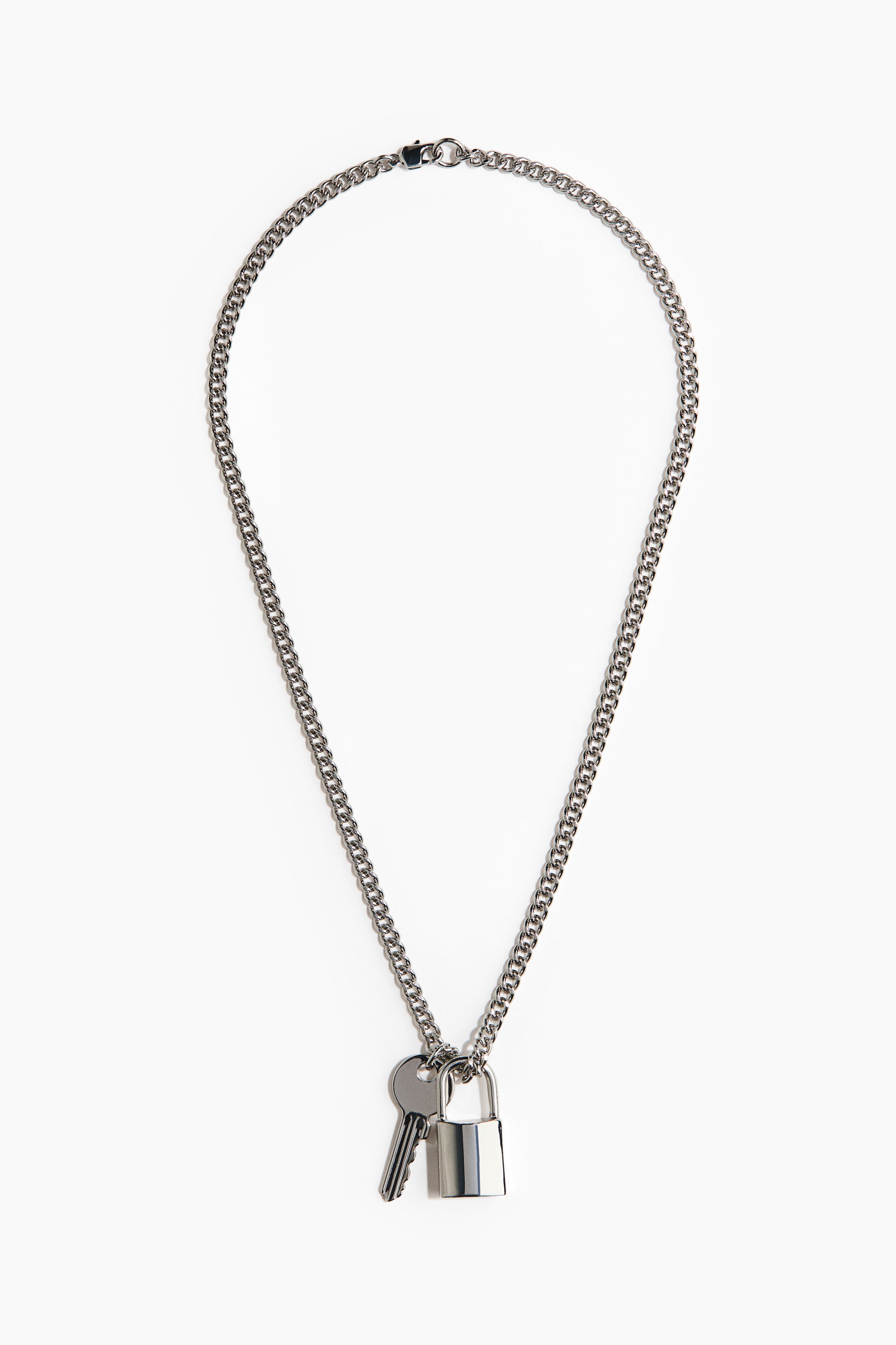 Visualizza l'immagine ingrandita: Una collana a catena piatta color argento è distesa, con una chiusura a moschettone nella parte superiore. Un piccolo lucchetto argentato lucido e una chiave abbinata pendono dalla parte inferiore della catena.