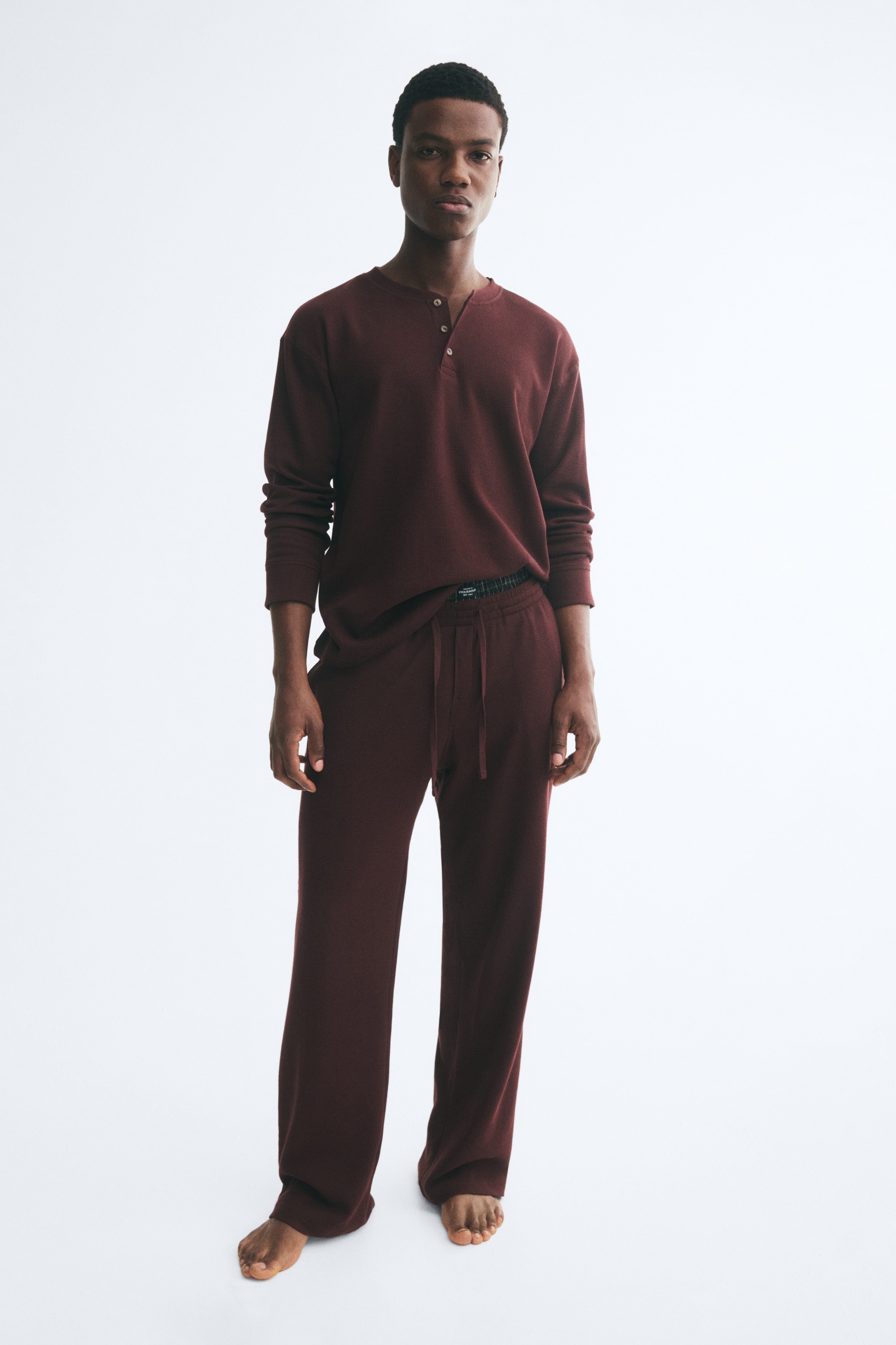 ÎÎ½Î± ÏÎµÏ loungewear Î±ÏÏ Î²Î±Î¼Î²Î±ÎºÎµÏÏ jersey ÏÎµ Î¼ÏÎ¿ÏÎ½ÏÏ ÏÏÏÎ¼Î± Î¼Îµ Î±Î½Î¬Î³Î»ÏÏÎ· ÏÏÎ® ÎµÎ¯Î½Î±Î¹ Î´Î¹ÏÎ»ÏÎ¼Î­Î½Î¿ ÏÎµ flat-lay ÏÏÎ¿Î²Î¿Î»Î®, Î±Î½Î±Î´ÎµÎ¹ÎºÎ½ÏÎ¿Î½ÏÎ±Ï Î­Î½Î± ÏÎ¿ÏÎºÎ¬Î¼Î¹ÏÎ¿ ÏÏÏÎ¿Ï Henley Î¼Îµ ÏÎ¹Î¼Ï ÏÏÏÎ¿Î³Î³ÏÎ»Î® Î»Î±Î¹Î¼ÏÎºÎ¿ÏÎ· ÎºÎ±Î¹ ÏÎ±ÏÎ¹Î»Î­ÏÎ± Î¼Îµ ÏÏÎ¯Î± ÎºÎ¿ÏÎ¼ÏÎ¹Î¬, ÏÎ¿ÏÎ¿Î¸ÎµÏÎ·Î¼Î­Î½Î¿ ÏÎ¬Î½Ï Î±ÏÏ Î±ÏÎ¿ÏÏÎ¯ ÏÎ±Î½ÏÎµÎ»ÏÎ½Î¹ Î¼Îµ ÎµÎ»Î±ÏÏÎ¹ÎºÎ® Î¼Î­ÏÎ· ÎºÎ±Î¹ ÎºÎ¿ÏÎ´ÏÎ½Î¹ ÏÏÏÏÎ¹Î¾Î·Ï.