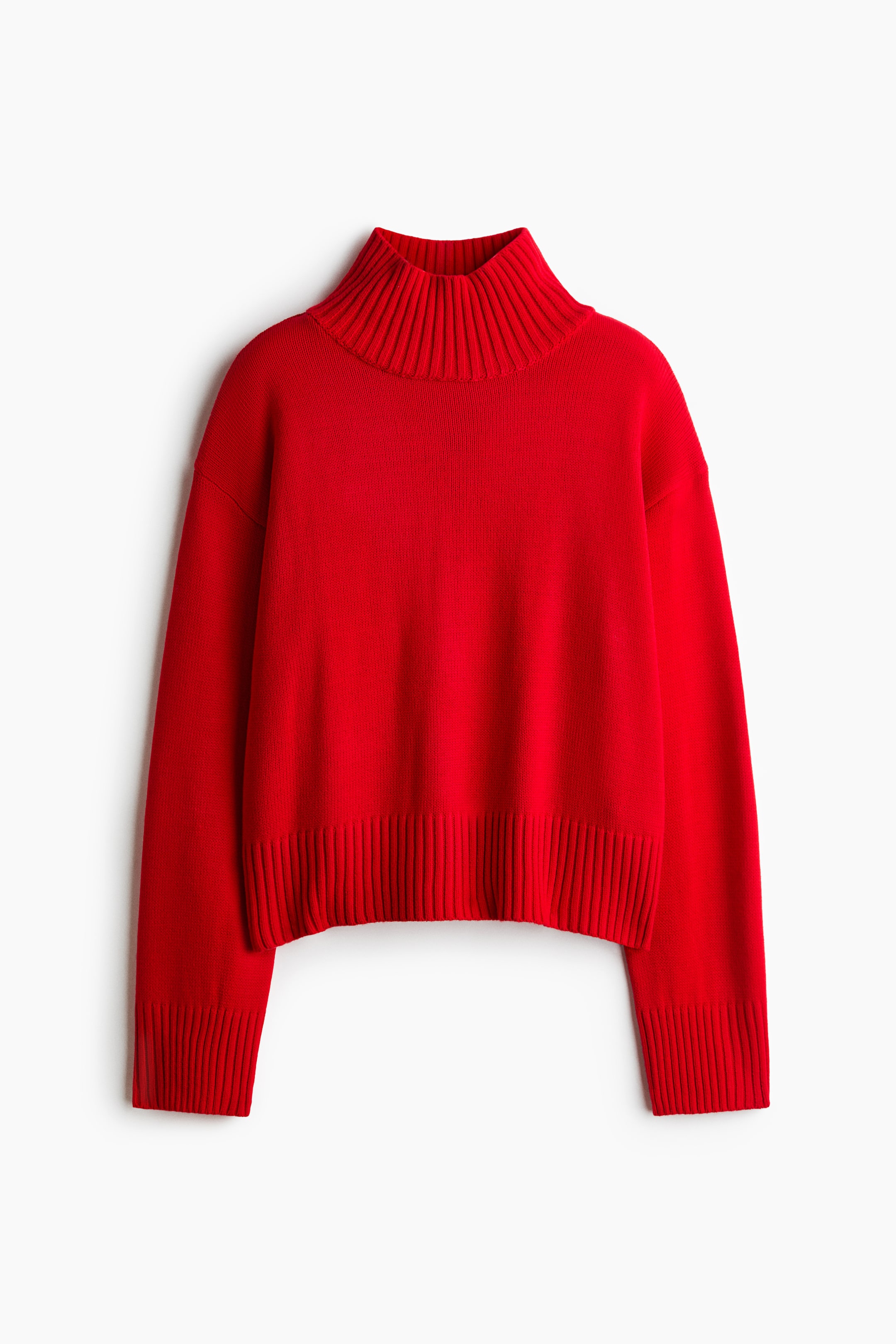 Agrandir l'image: Un pull en maille rouge est présenté de face, avec un col montant côtelé, des épaules tombantes et des manches longues avec de larges poignets côtelés. Le vêtement affiche une silhouette décontractée, légèrement courte, avec un large bord côtelé assorti.