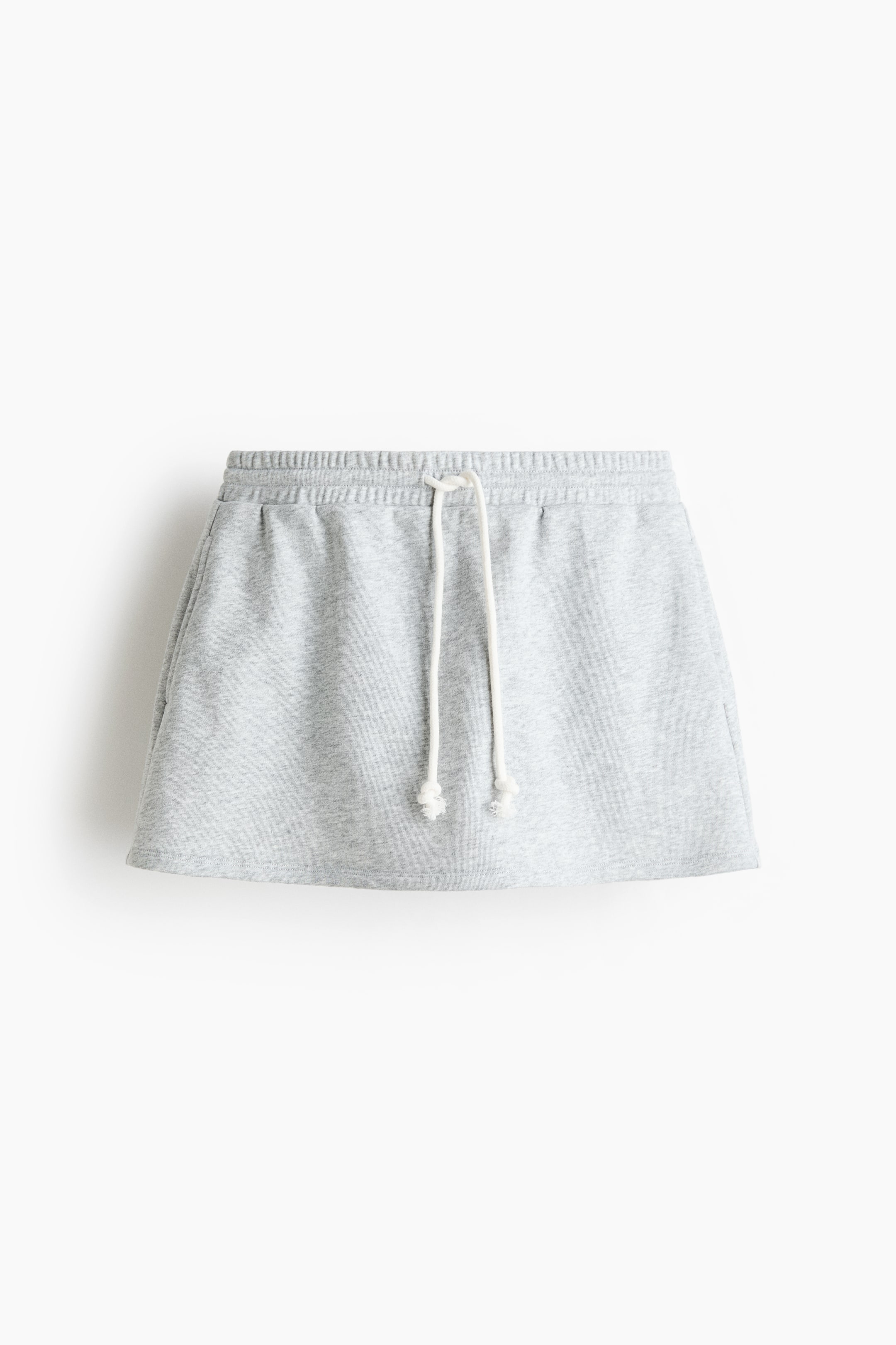 View larger image: A heather grey skirt is displayed at the FRONT, featuring an elasticated waistband with a white drawstring ending in knotted tips, made from a soft sweatshirt material, and showcasing two angled side pockets.