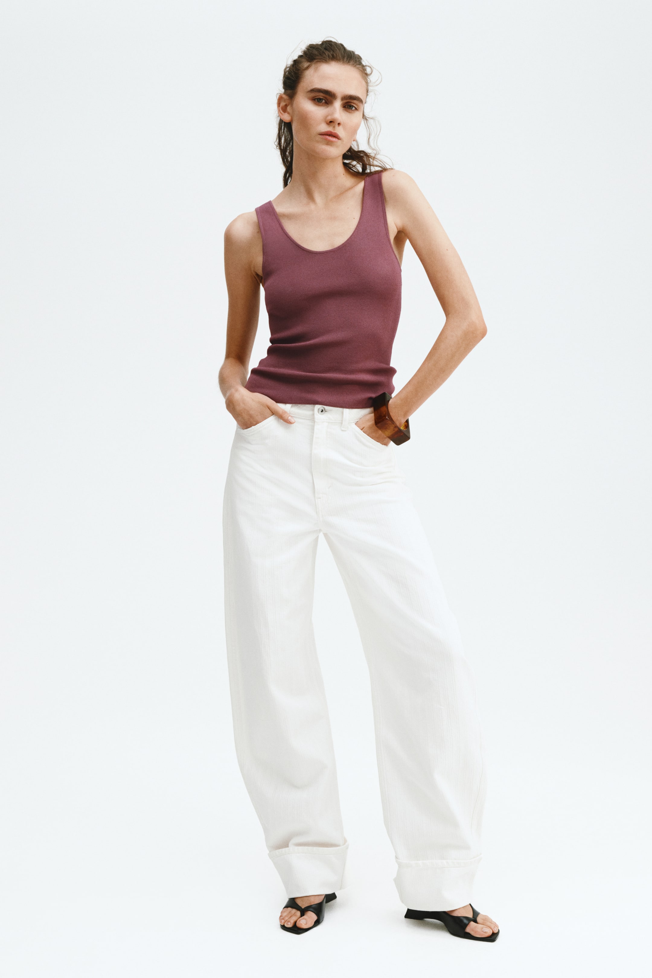 Prikaži veću sliku: Bele pantalone širokih nogavica prikazuju tkaninu sa teksturom vertikalnih pruga i širokim porubljenim rubovima, gledano iz frontalnog ugla.