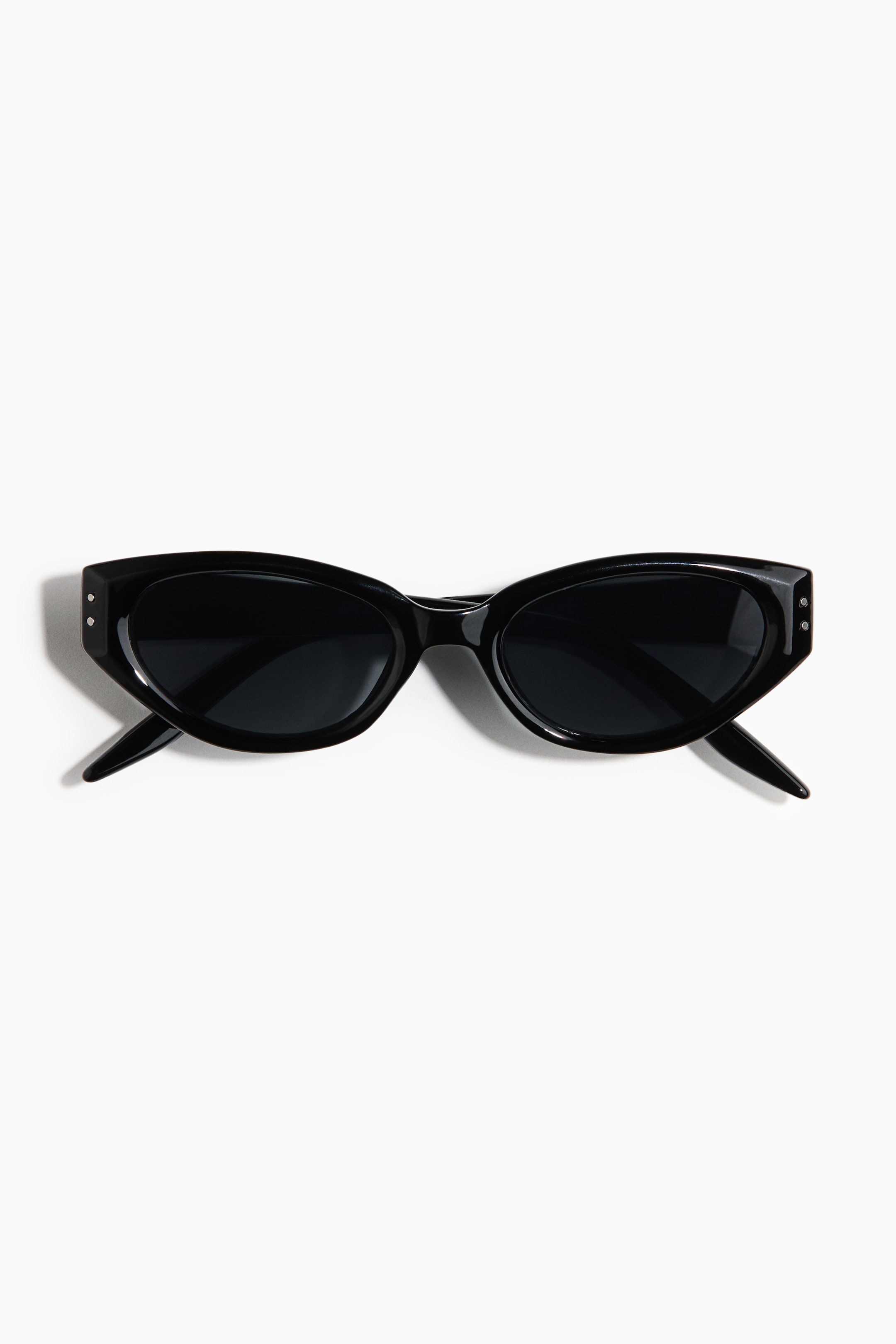 View larger image: Black cat-eye sunglasses are showcased from a front view, featuring dark lenses and two small silver studs detailing each outer frame edge.
