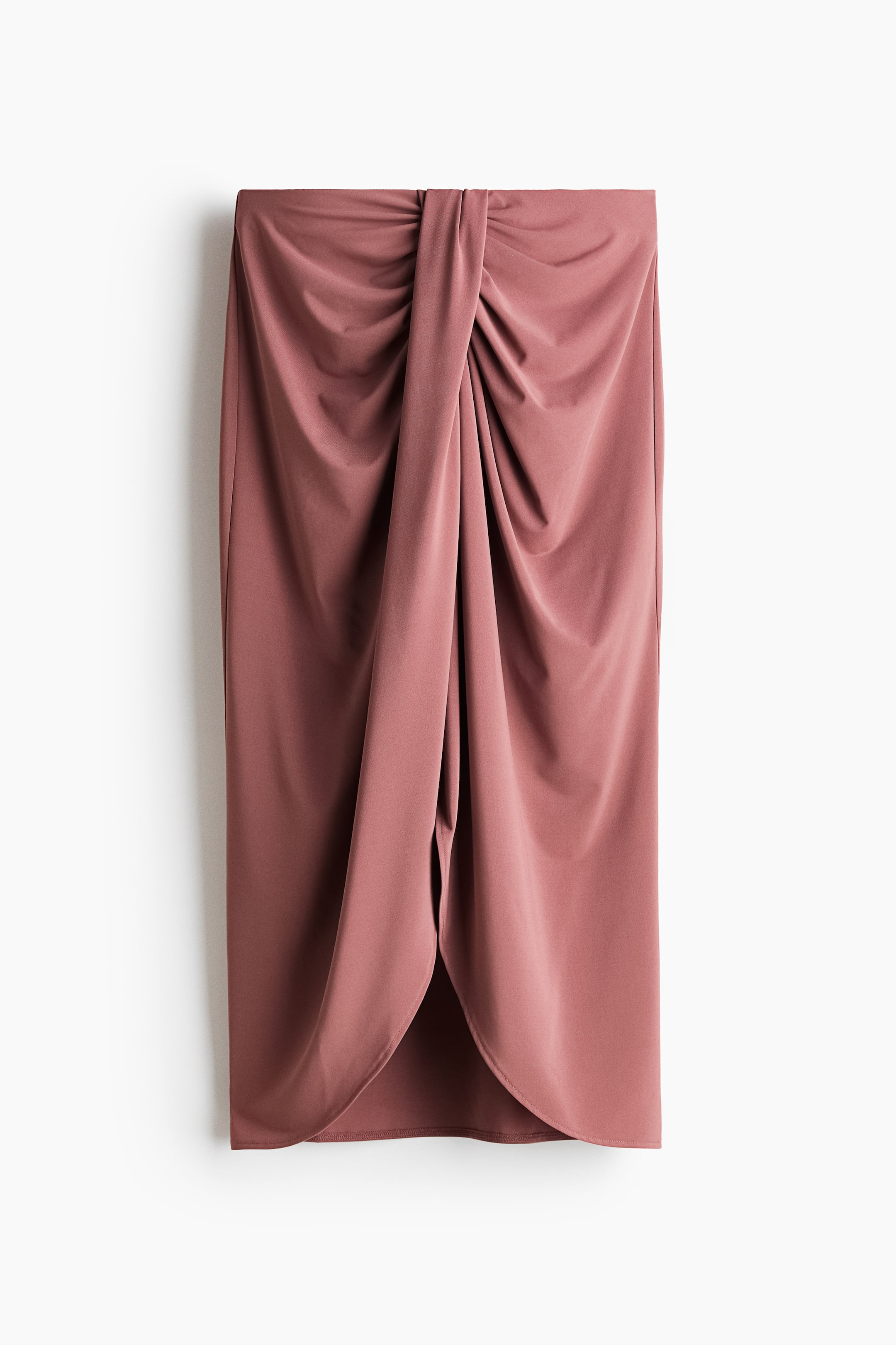 View larger image: A dusty rose midi skirt is facing front, showcasing a draped knot detail at the waist, forming a tulip-style overlap at the front hem.