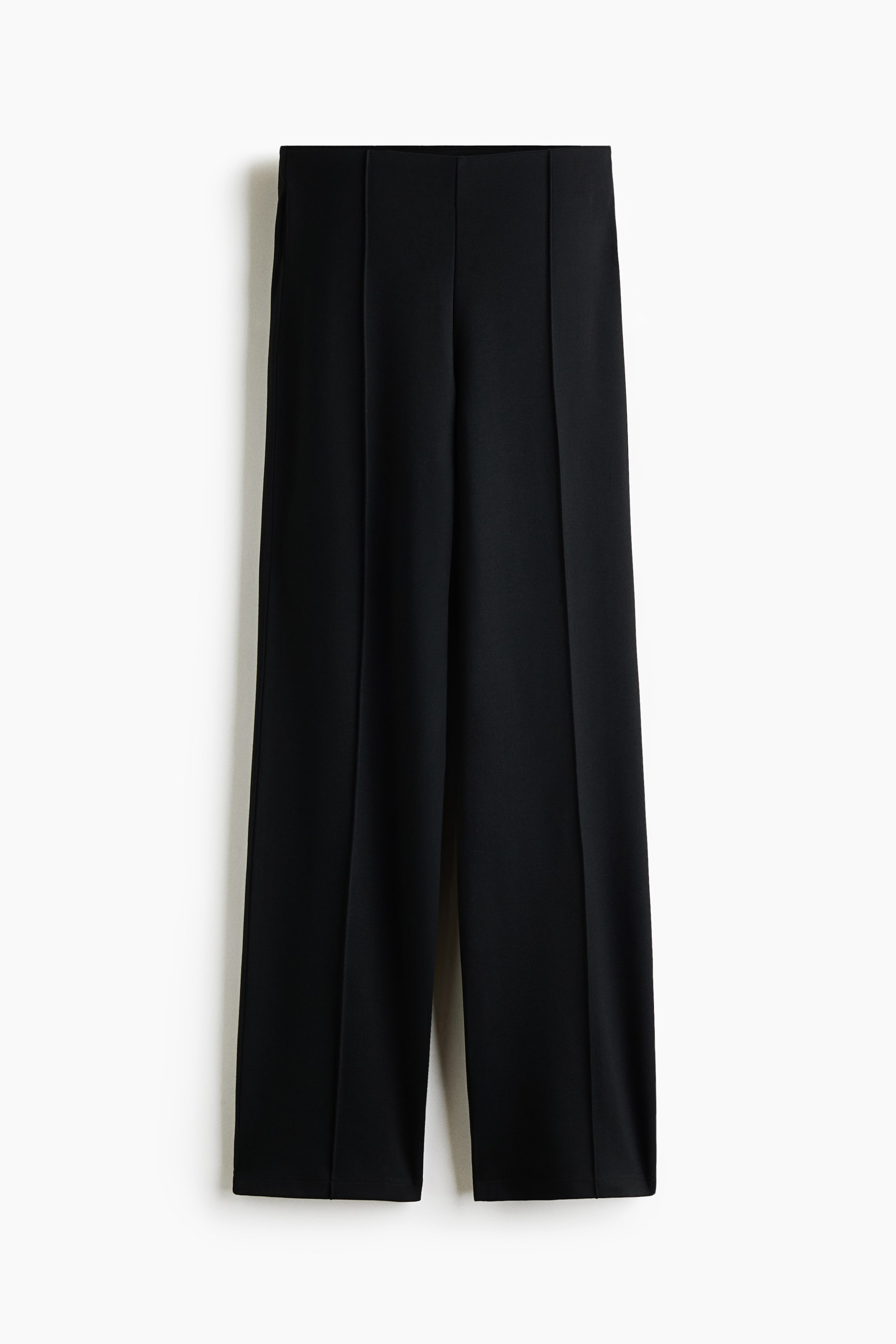 Größeres Bild anzeigen: Schwarze Hose aus Ponte-di-Roma-Jersey, von vorne gezeigt, mit hoher Taille und verdecktem elastischem Bund. Das Design zeichnet sich durch eine schmale Passform aus, mit markanten Bügelfalten, die mittig an jedem Bein verlaufen und zum Saum hin in eine leichte ausgestellte Form übergehen.