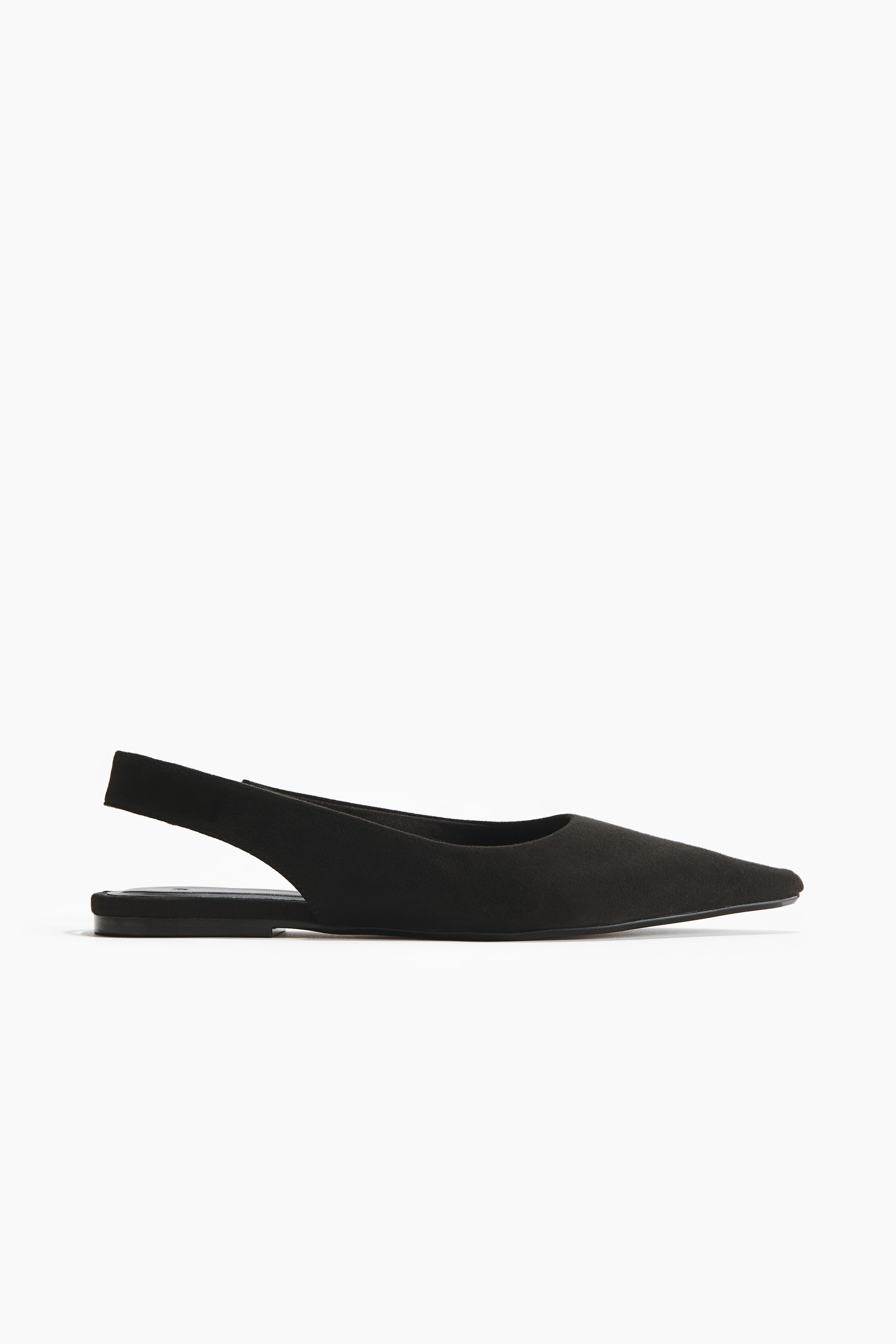 View larger image: The side profile of a black slingback shoe is showcased, highlighting its pointed toe and flat sole. The heel strap elegantly wraps around the back of the shoe.