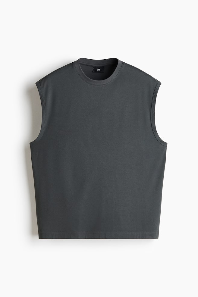 A dark grey sleeveless t-shirt is facing front, showcasing a ribbed crew neckline and wide, clean-finished armholes. The garment is featuring a relaxed silhouette and a straight, double-stitched hemline. - 1