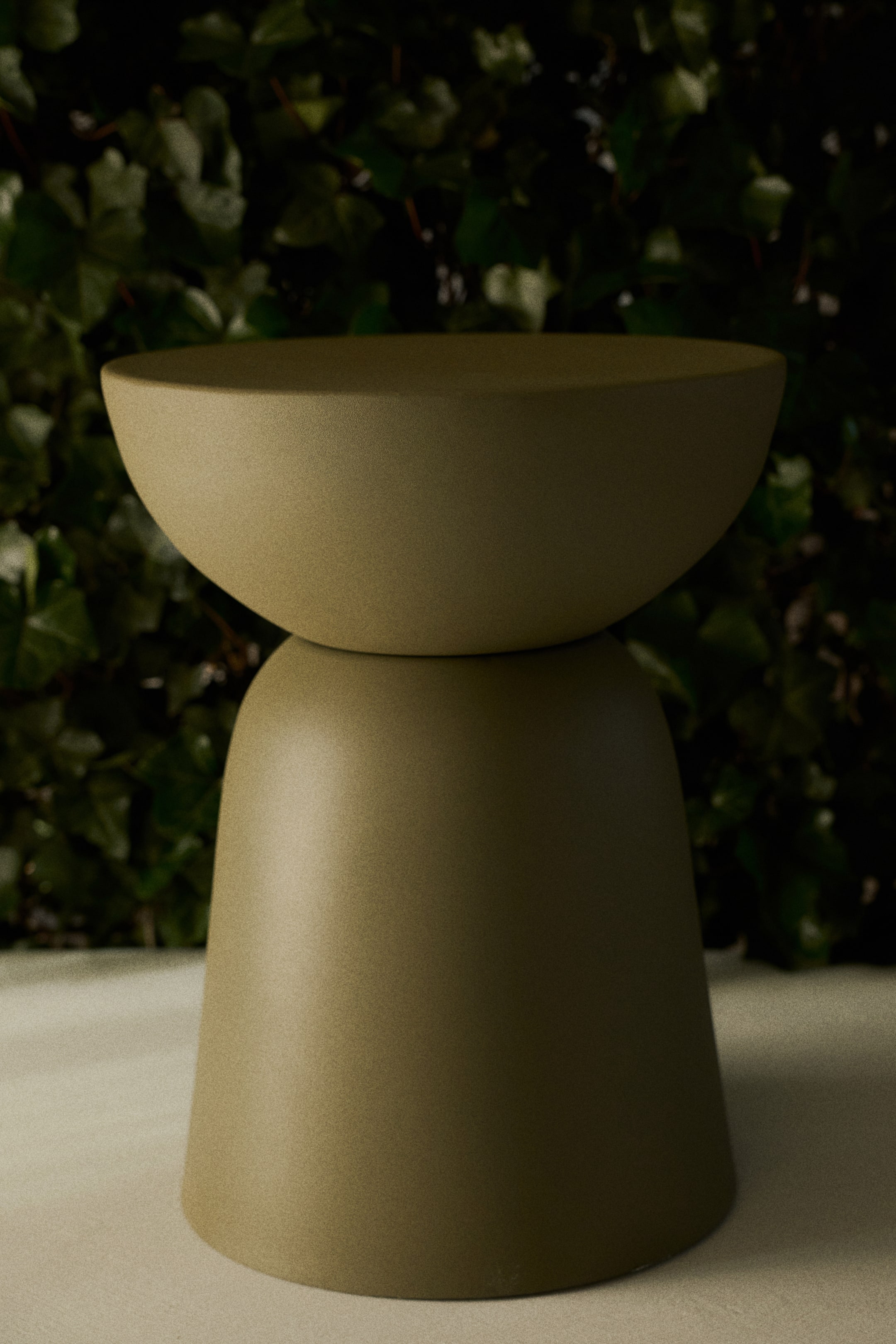 View larger image: An olive-green, two-piece object is standing, facing forward. Its upper section is a shallow, inverted bowl resting on a wider, bell-shaped base, both featuring a matte, slightly textured finish.
