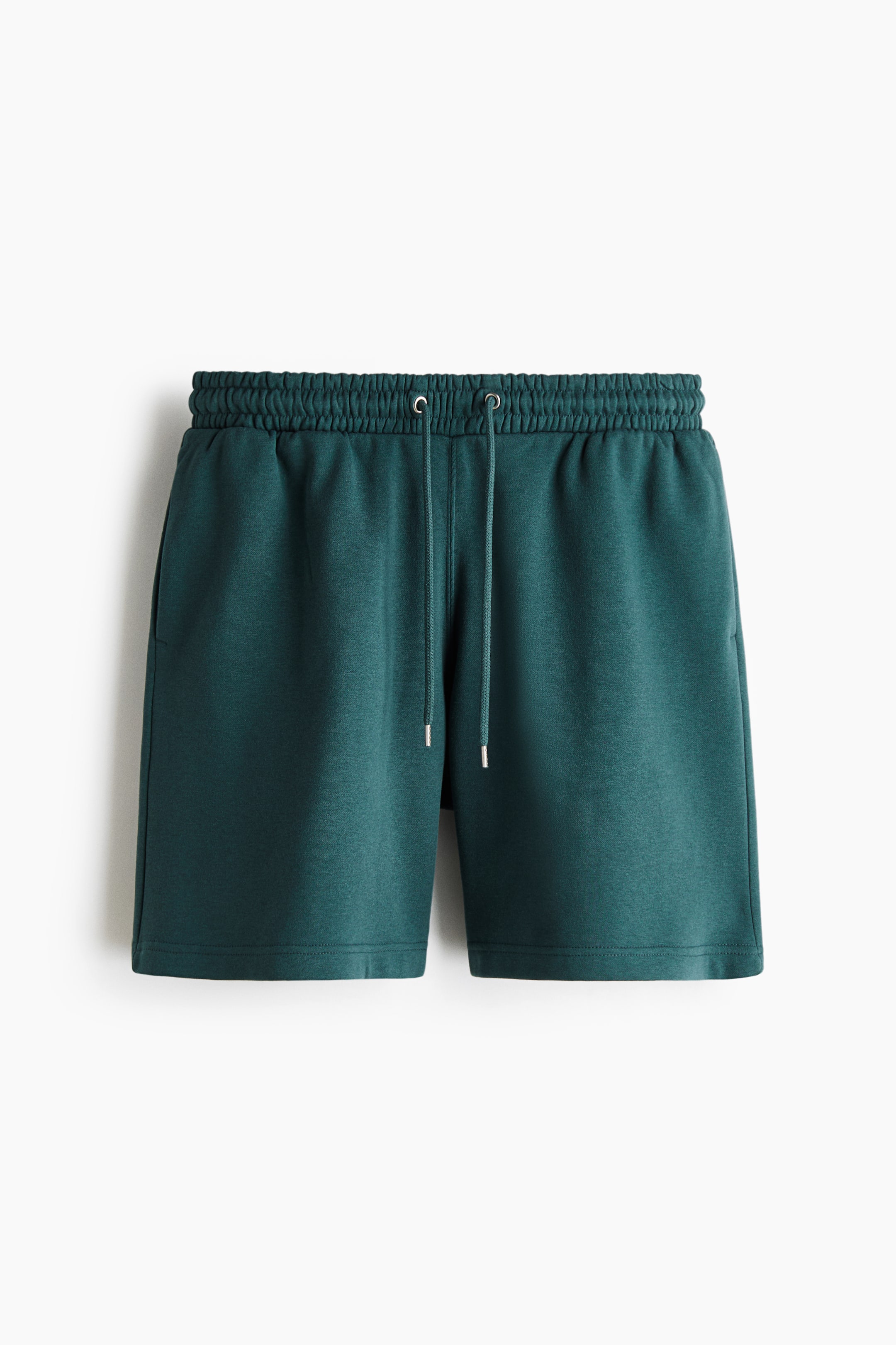 View larger image: Dark green shorts are displaying a front view, featuring an elasticated drawstring waistband with metal aglets. Side pockets are integrated, and the legs are finishing with a straight hem.