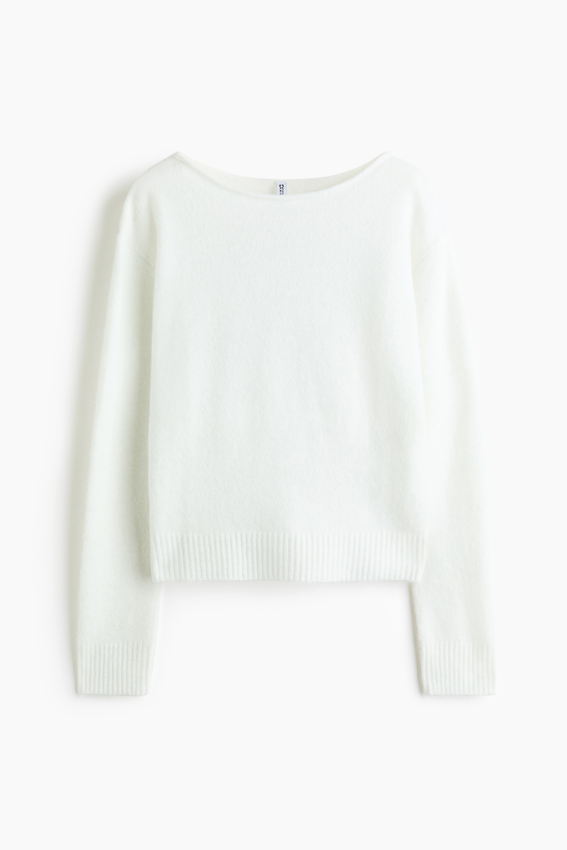 A white, soft-knit sweater featuring a silver sequined angel wings design on the back is being worn by the model. The sweater has a boat neck with a rolled edge and a ribbed hem, and is styled with blue jeans.