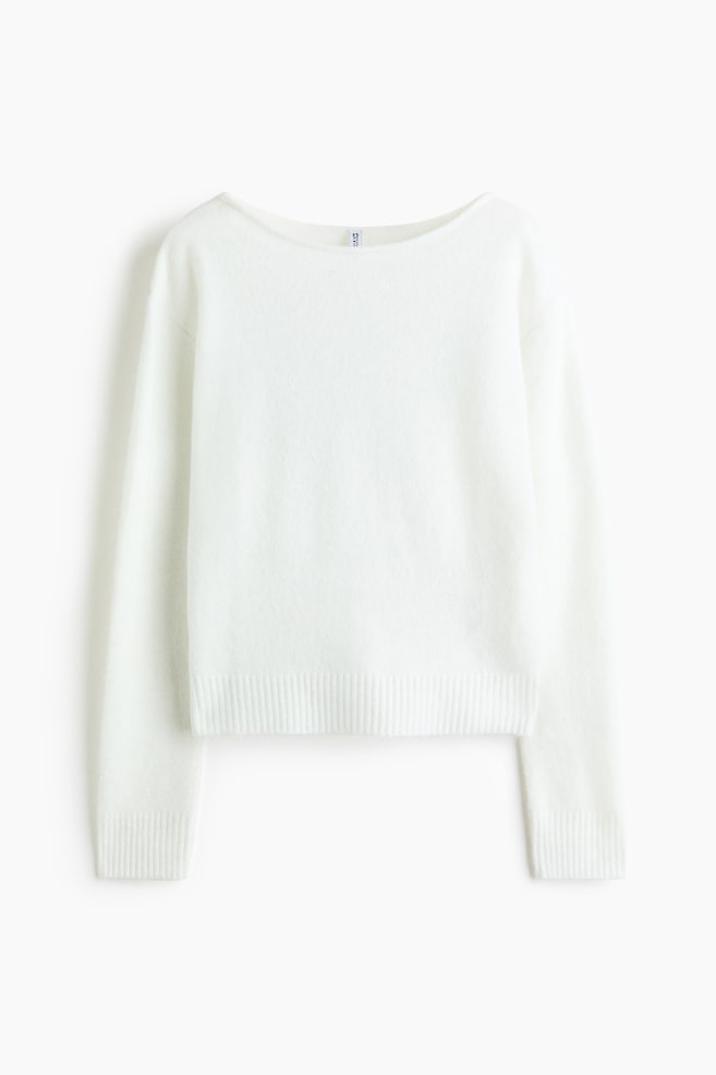 Se muestra un jersey de punto blanco desde el frente, con un amplio escote barco y mangas largas. El jersey presenta una textura suave y afelpada, rematada con un bajo acanalado y puÃ±os acanalados. - 1