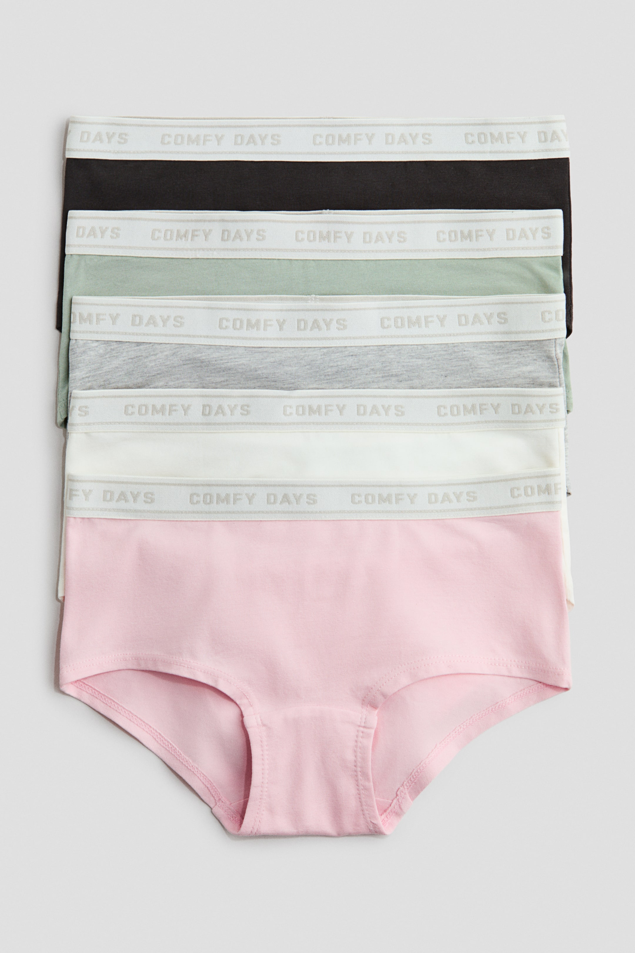 View larger image: A stack of five hipster briefs is displayed, with their fronts facing forward. They're crafted from soft cotton jersey in black, light green, grey, white, and pink, each showcasing visible elastication at the waist with "COMFY DAYS" text motifs, and a lined gusset.