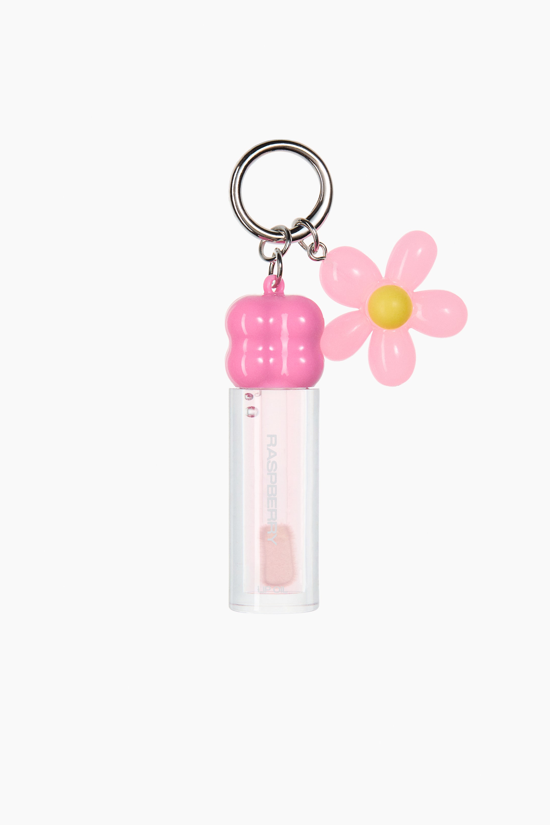 Ver imagem maior: Um porta-chaves prateado está a segurar um pequeno frasco transparente de óleo labial e um pendente em forma de flor cor-de-rosa com centro amarelo. O frasco de óleo labial, virado para a frente, apresenta uma tampa bulbosa rosa brilhante e o texto "RASPBERRY" impresso na vertical no seu corpo cilíndrico transparente.