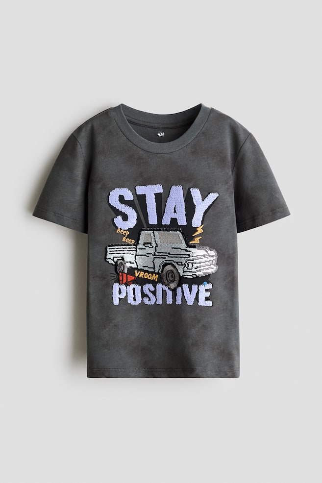 リバーシブルスパンコールデザインTシャツ - ダークグレー／Stay Positive/クリーム／カー - 1