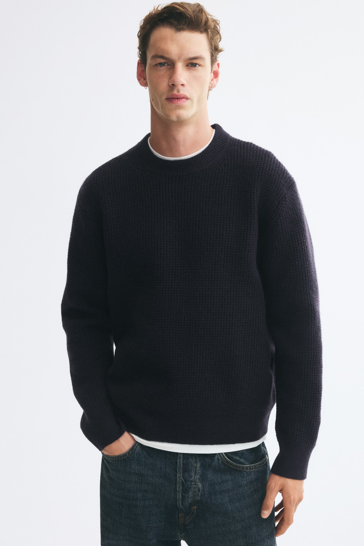 A dark navy blue crewneck jumper is shown from the front, showcasing a textured knit pattern, a round ribbed neckline, long sleeves with ribbed cuffs, and a ribbed hem. - 1