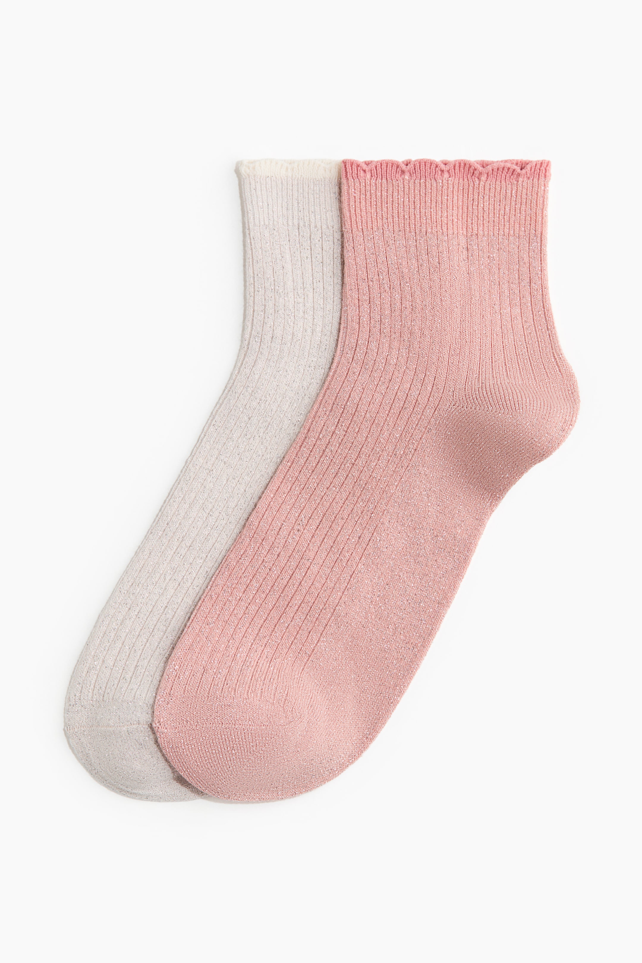 Ingrandisci l'immagine: Due calzini sono distesi, mettendo in mostra la loro texture a maglia a coste e i fili scintillanti. Un calzino è grigio chiaro con un bordo semplice, mentre l'altro è rosa chiaro con un bordo arricciato.