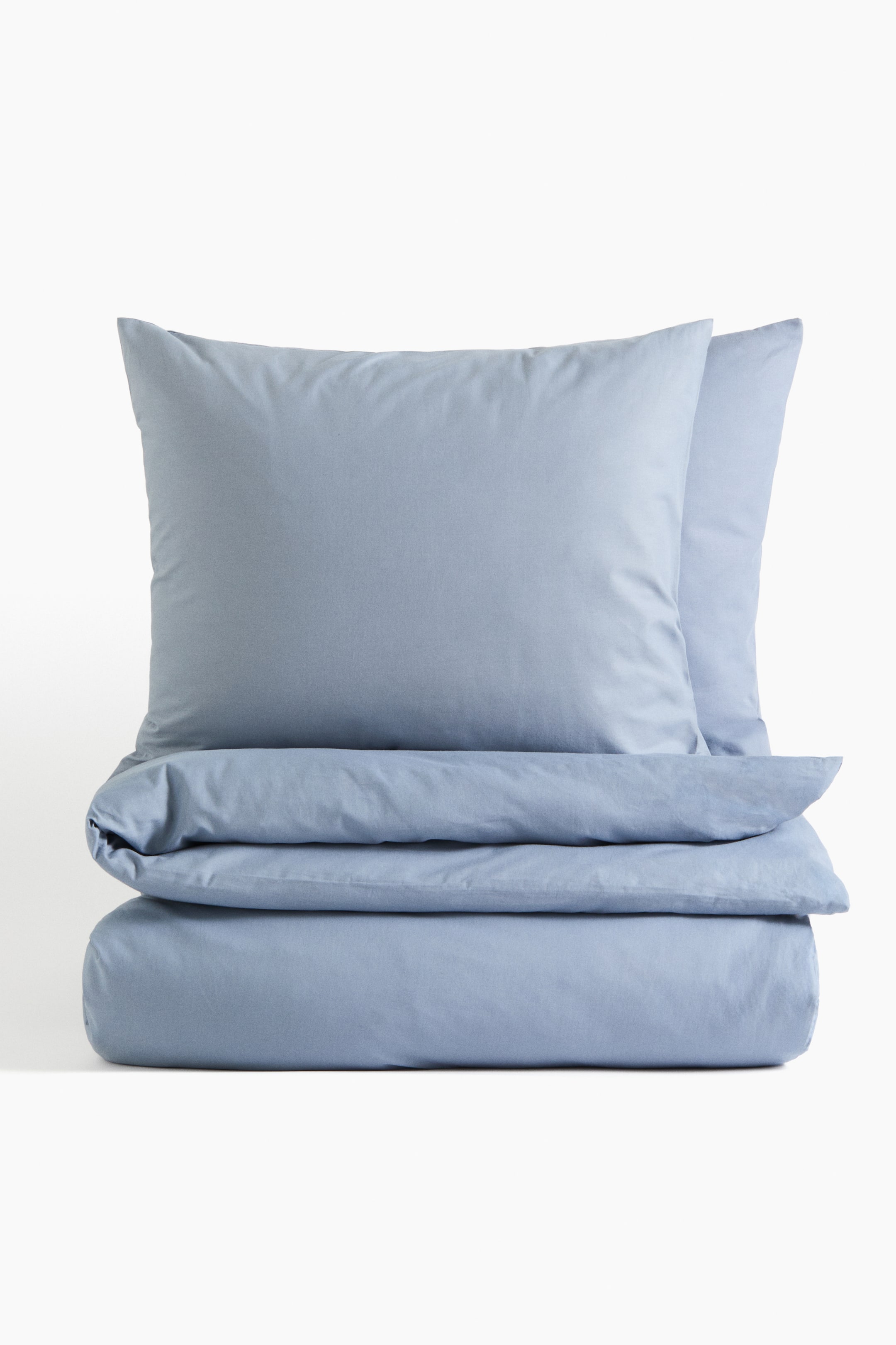 View larger image: Presenting a light blue double duvet cover set from the front. The duvet cover is neatly folded in two layers at the bottom, with two matching pillowcases stacked atop the folded duvet cover.