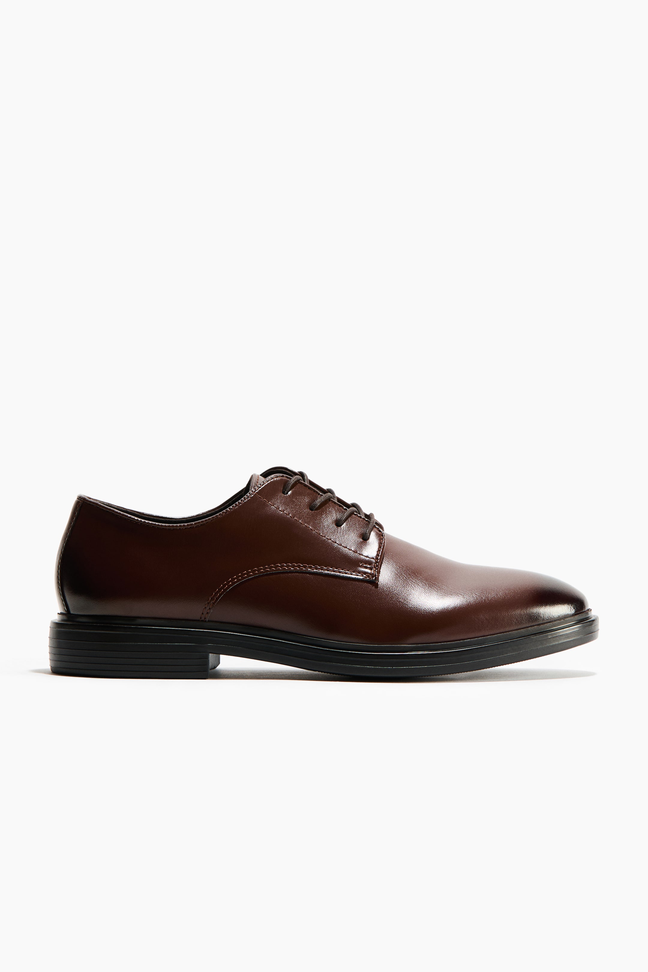 View larger image: A dark brown derby shoe showcases a glossy finish with an open-lacing system, four pairs of eyelets, and a plain toe. It features a black sole with a low block heel.
