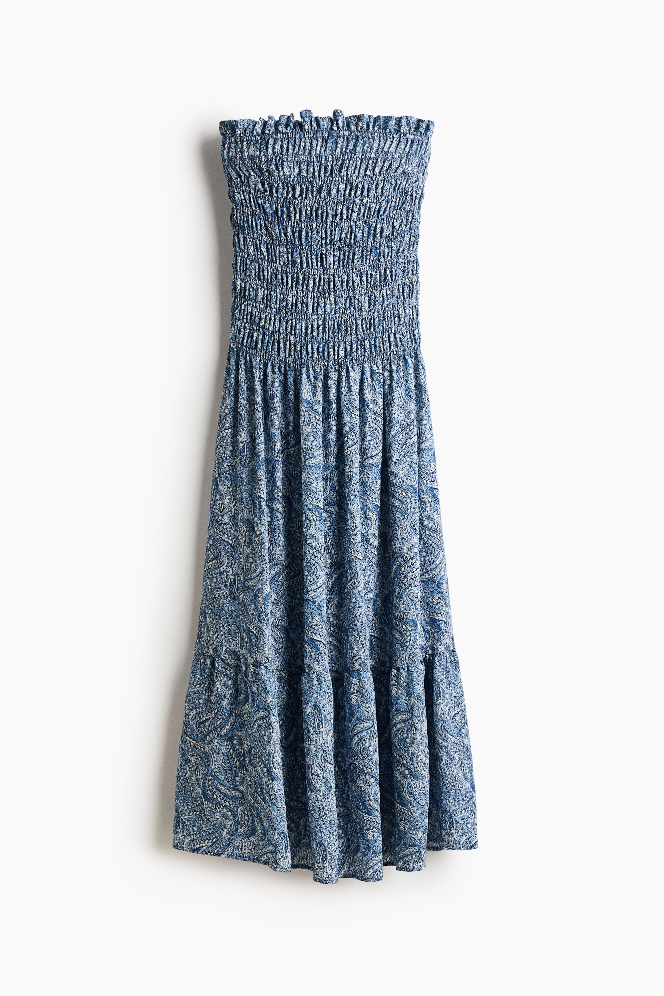 Ver imagen más grande: Un vestido bandeau hasta el tobillo de frente muestra un estampado de cachemira azul y blanco. Presenta un corpiño fruncido con un ribete de volantes en la parte superior, y una falda ligeramente acampanada fluye desde el corpiño, mostrando un volante recogido a la altura de la rodilla.