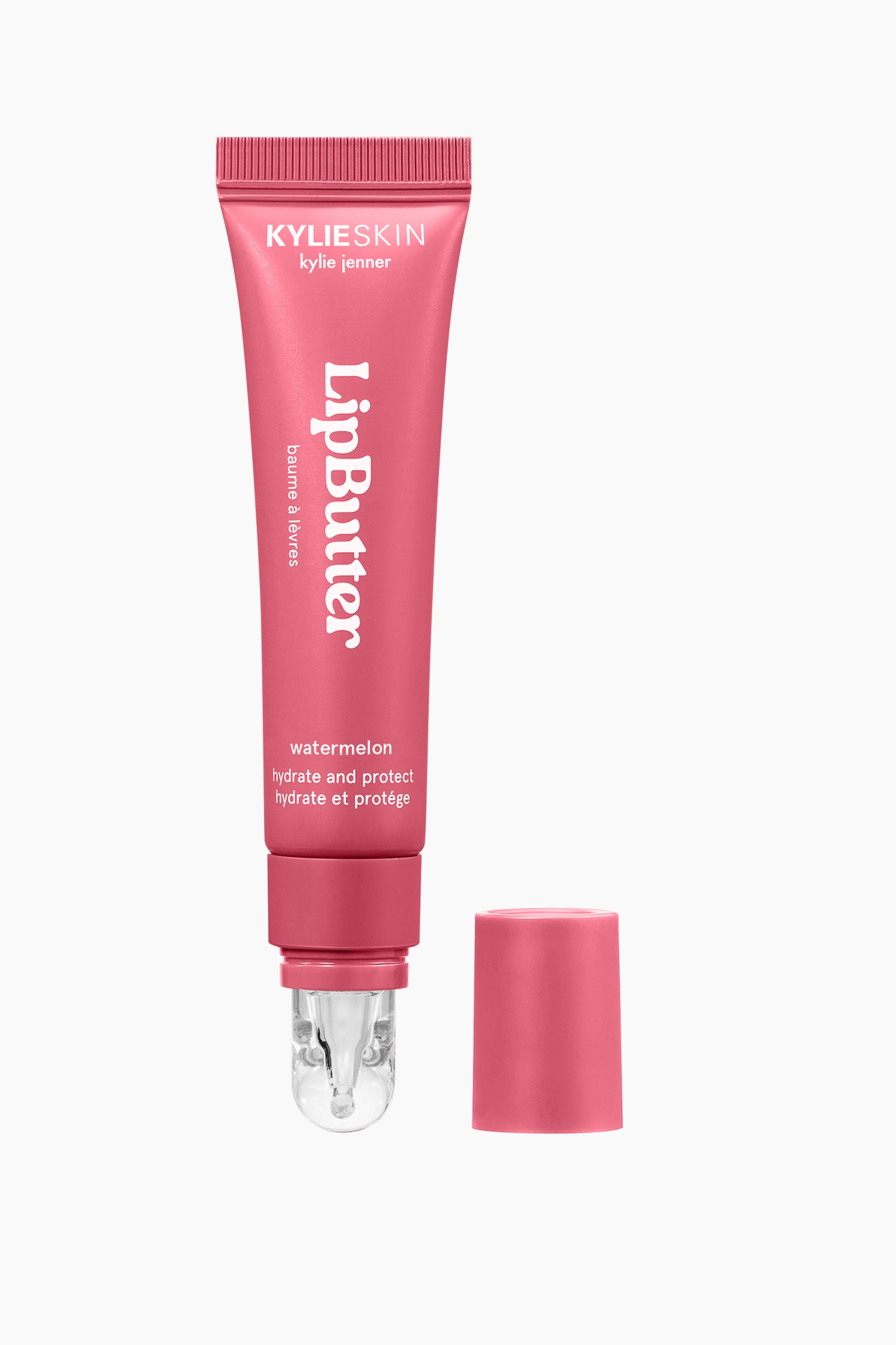 Visa större bild: En rosa squeeze-tub av Kylie Skin Lip Butter står lodrätt och har en genomskinlig, rundad applikatornippel längst ned. Det matchande rosa cylindriska locket är avtaget och står upprätt bredvid spetsen till höger.