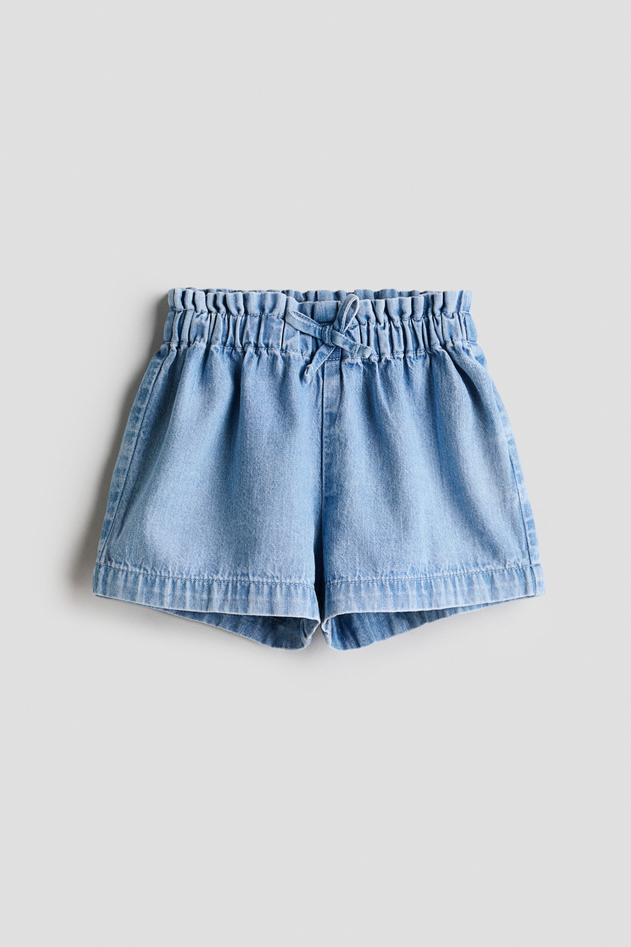 View larger image: Shorts shown as FRONT, featuring a soft, light-blue weave. They are designed with an adjustable paper‑bag waist, tied with a decorative bow at the front.