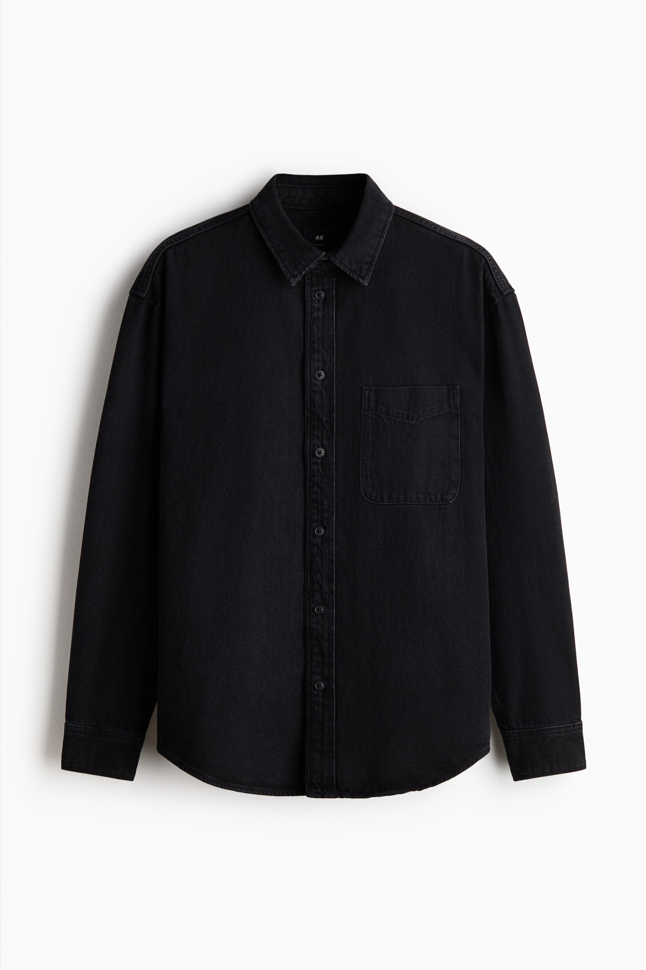Agrandir l'image: Une chemise en denim noir est présentée à L'AVANT, dotée d'un col standard, d'une patte de boutonnage complète avec des boutons noirs, et d'une poche poitrine unique sur le côté gauche. Elle présente des manches longues avec des poignets boutonnés et un ourlet incurvé.