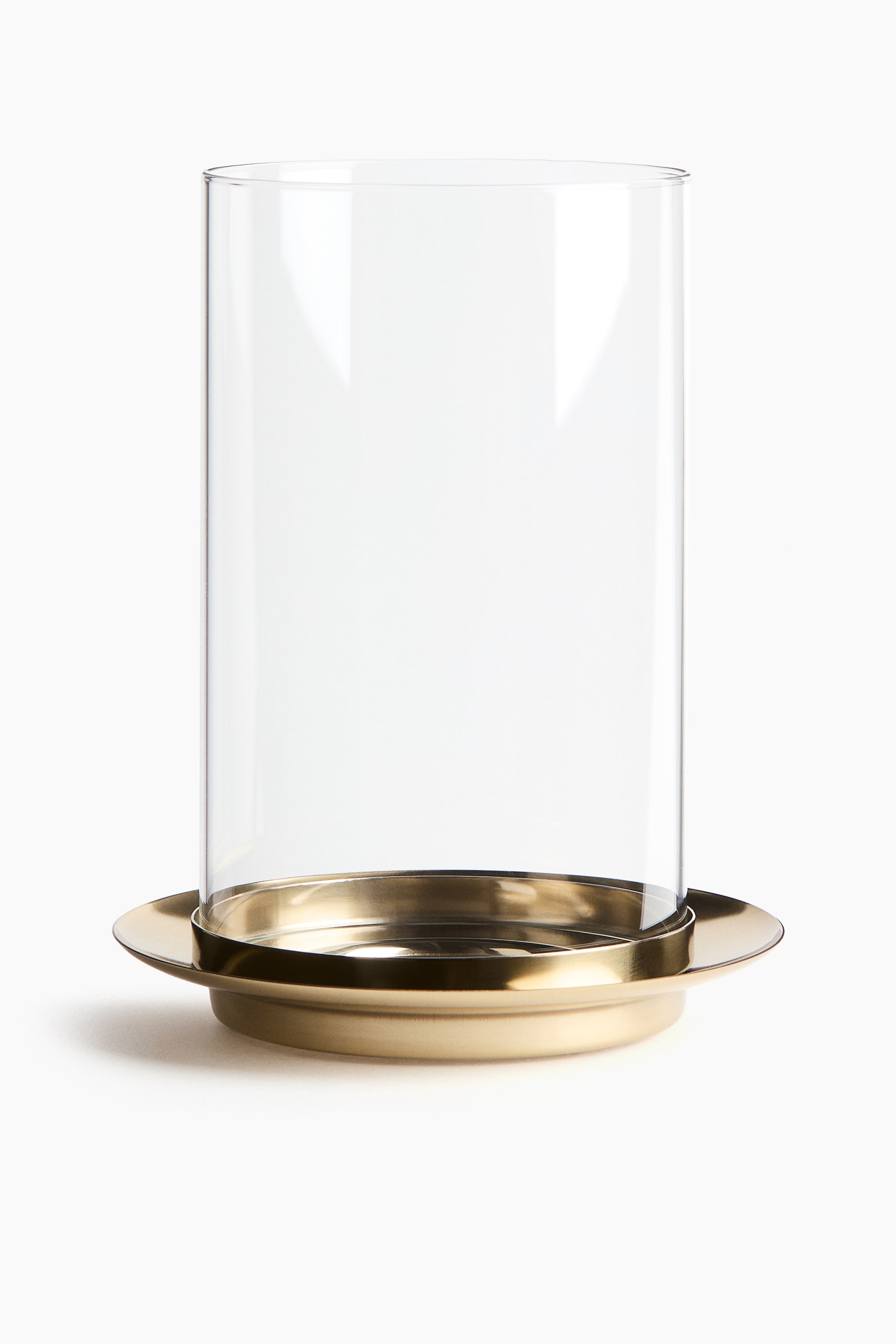 View larger image: A tall, clear glass cylinder rests on a round, gold-toned metal base. The glass sits within a recessed circular area on the base, which features a wider, flat rim.