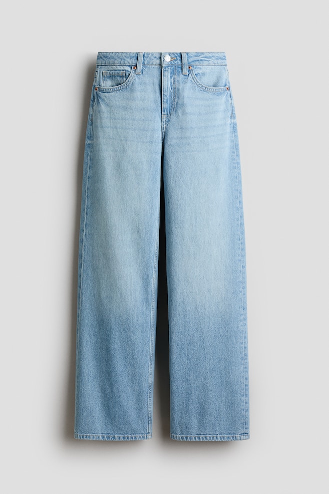 Light blue wide-leg jeans are hanging flat, featuring a faded wash. They display a button and zip fastening, belt loops, two front pockets, a coin pocket, and visible vertical seams along the outer legs. - 1