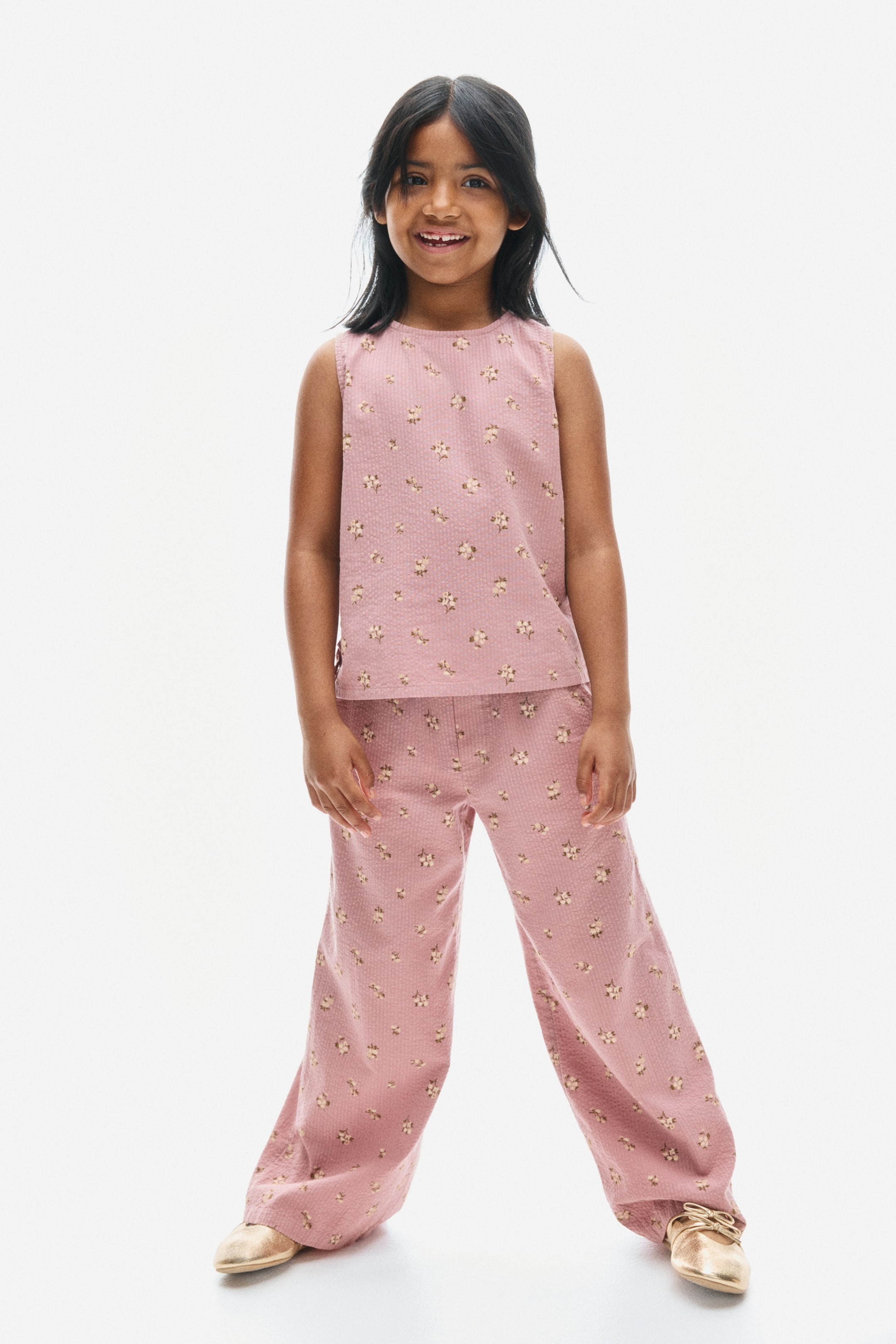View larger image: A matching two-piece set in dusty pink, floral-patterned seersucker cotton is being displayed from the front, featuring a sleeveless top with a round neckline and matching straight-leg pants.