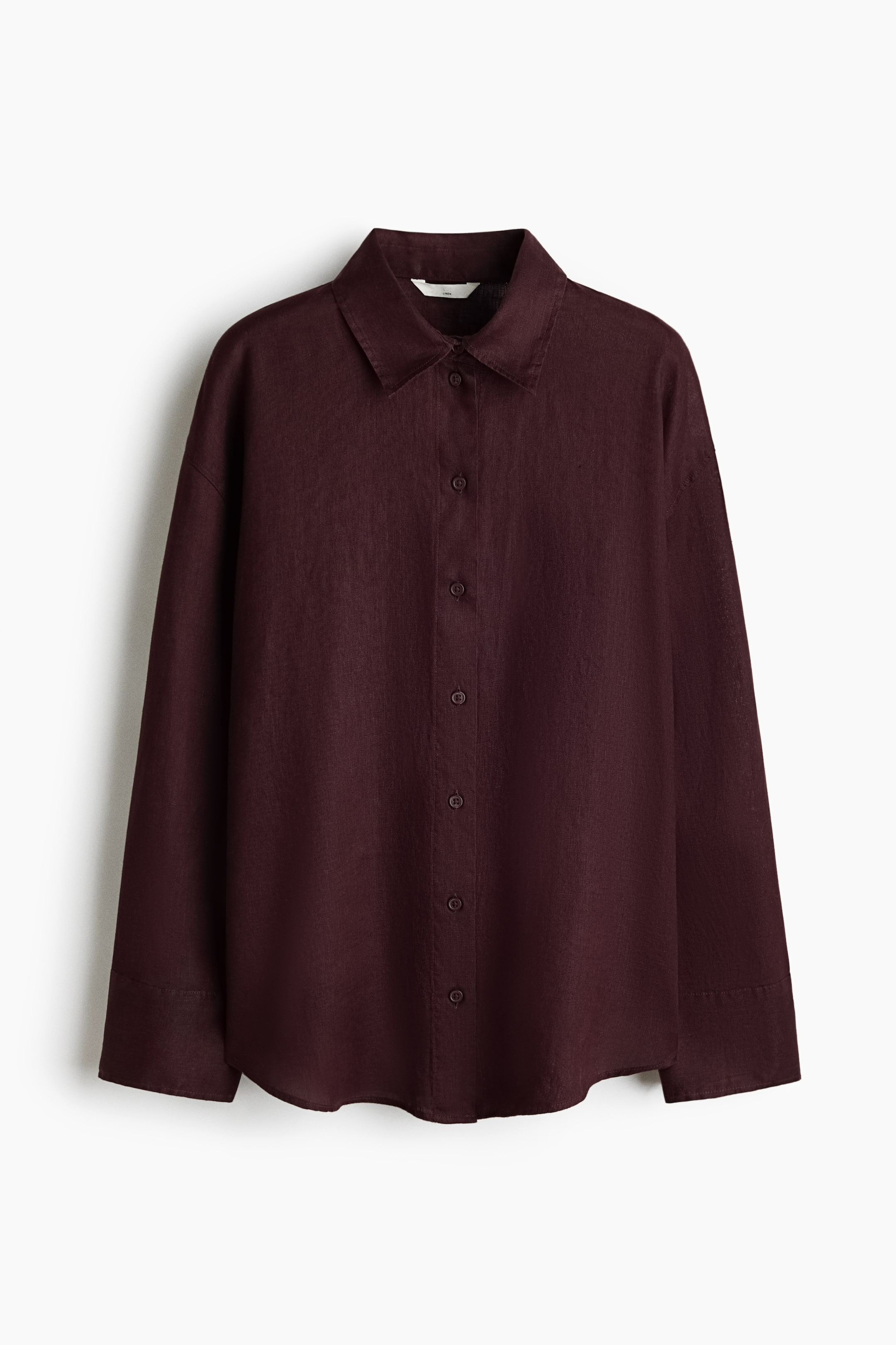 View larger image: An oversized shirt in a deep red, airy linen weave showcases its front, featuring a collar, buttons down the front, dropped shoulders, long sleeves with buttoned cuffs, and a gently rounded hem.