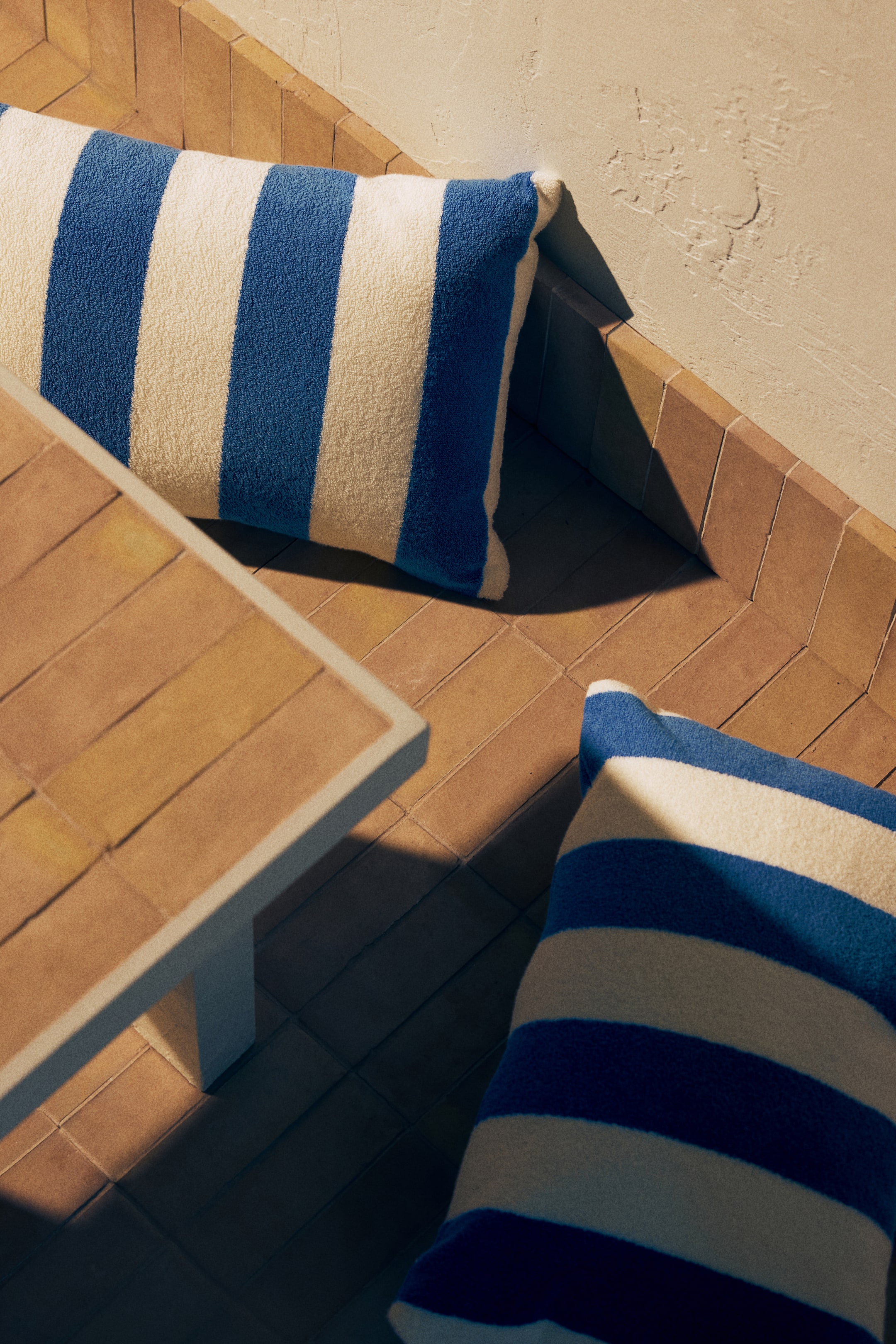 View larger image: The product consists of two rectangular cushions, featuring alternating blue and off-white stripes across their terry fabric surface. They are positioned at an angle, highlighting their full shape and stripe pattern.