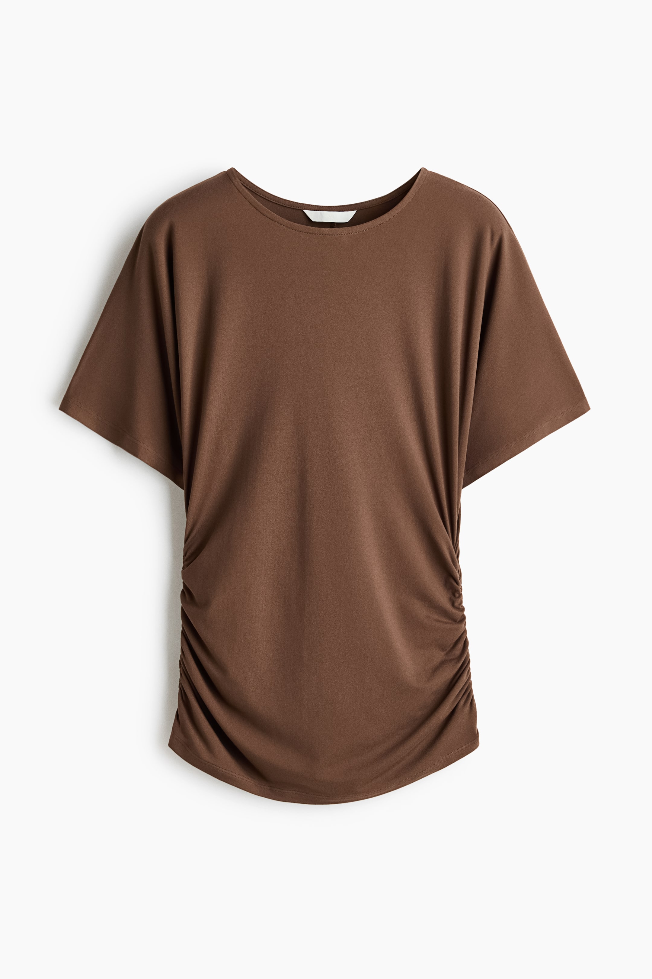 View larger image: A brown top is showcasing its front view, featuring a round neckline, dolman sleeves, and ruching detail along its left side, finishing with a curved hem.