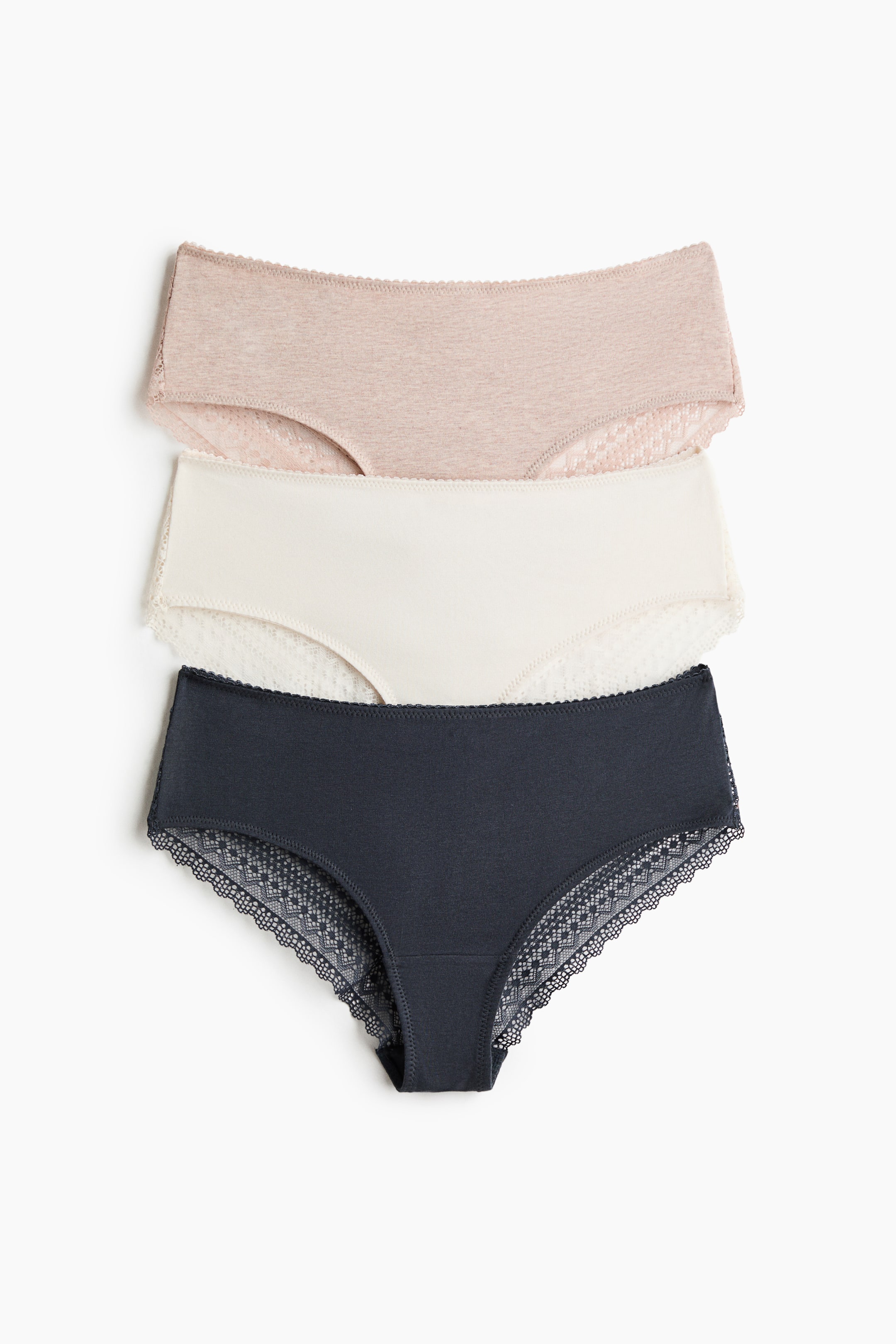 View larger image: Three mid-rise briefs are layered, with the top brief in light beige, the middle in off-white, and the bottom in dark grey. Each brief features cotton jersey fabric with delicate lace trim detailing the leg openings and partially along the waistband.