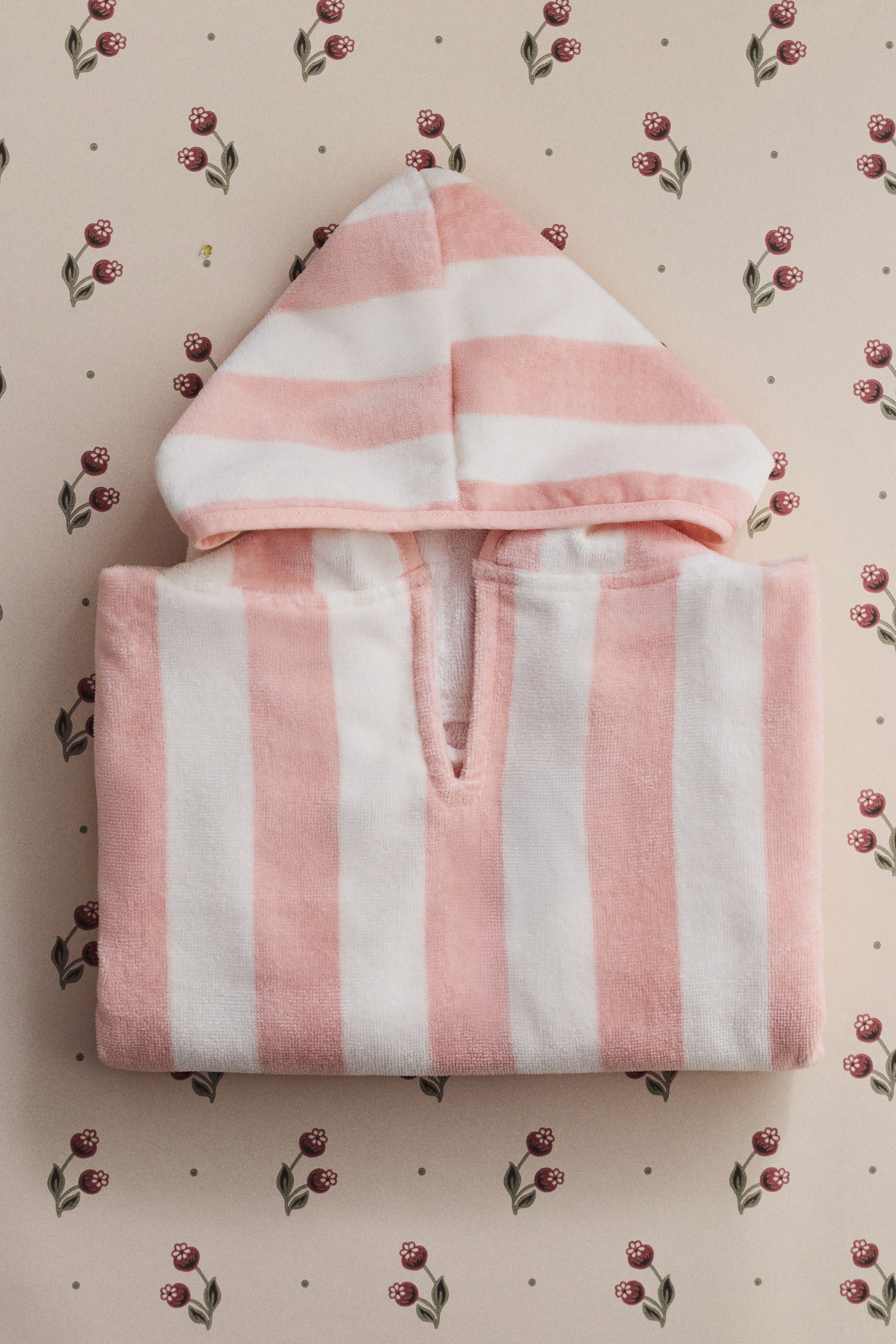 Nagyobb kép megtekintése: A puha pamut frottír törölközőköpeny ELEJE látható, amely rózsaszín és fehér csíkos mintával, kapucnival, V-nyakú nyílással, nyitott oldalakkal és keskeny kötőkkel rendelkezik.