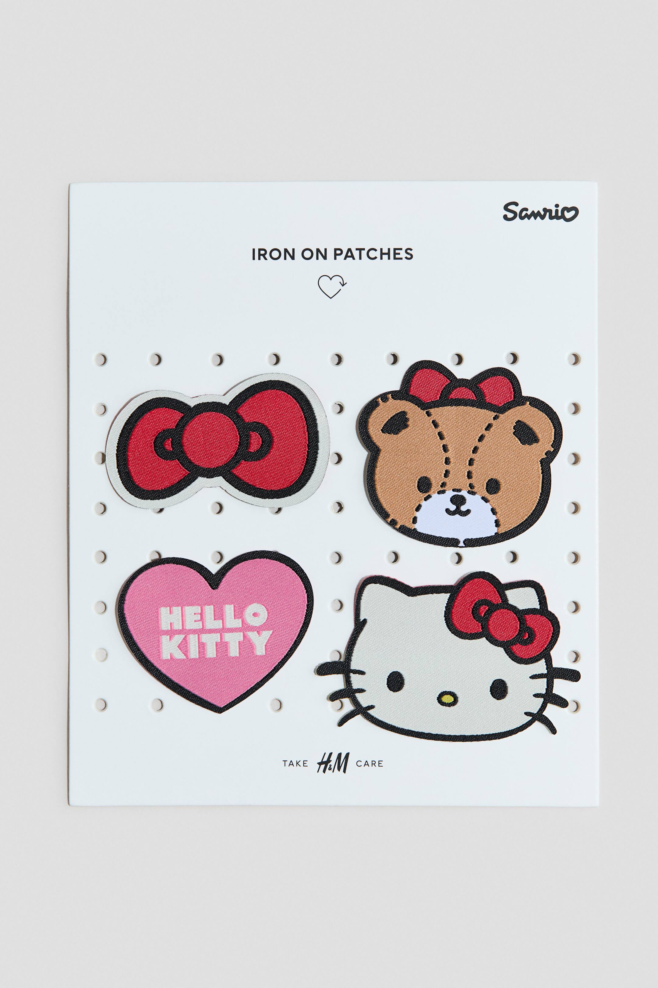 View larger image: A set of iron-on patches showcases four unique designs. The patches include a red bow, a brown bear head adorned with a red bow, a pink heart featuring the "HELLO KITTY" text, and a white Hello Kitty head with a red bow, all outlined in black and neatly displayed on a white backing card.