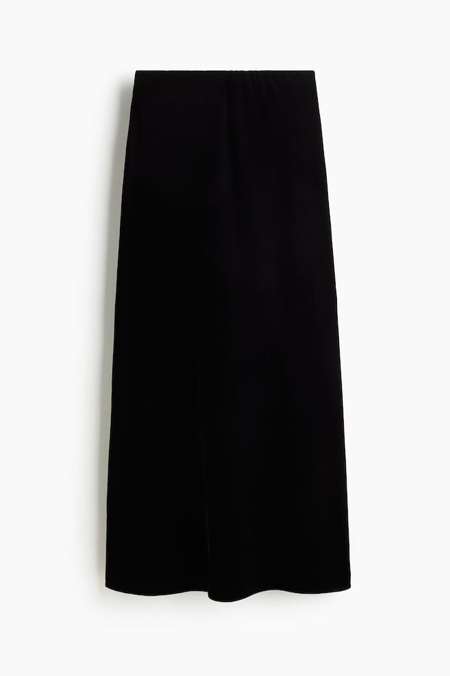 Una falda midi negra presenta una silueta recta y columnar desde el frente. Cuenta con una cintura elástica sutilmente fruncida y una tela suave y fluida. - 1