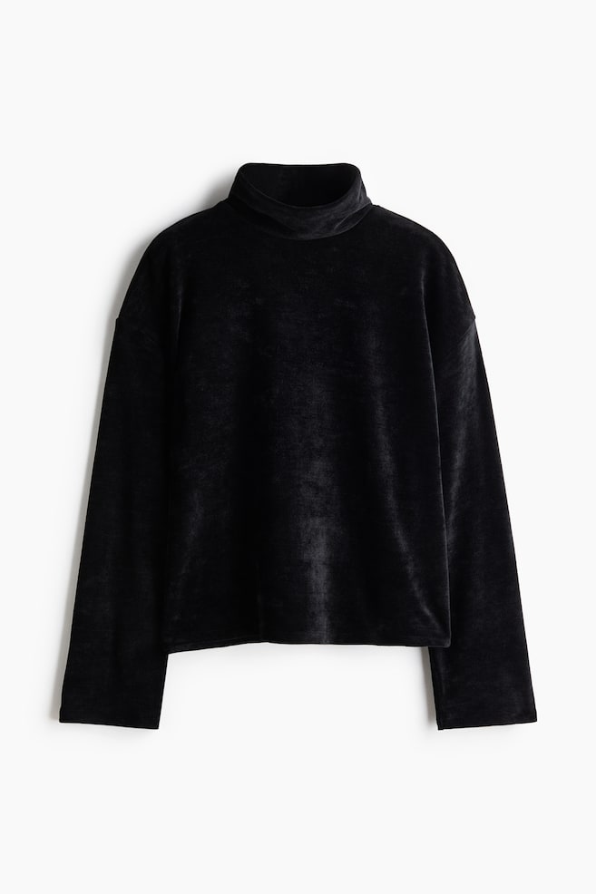 Un top nero in velluto con collo montante Ã¨ ripreso frontalmente, mettendo in risalto una silhouette morbida e squadrata, con spalle scese, maniche lunghe e ampie e un tessuto soffice dalla texture vellutata. - 1