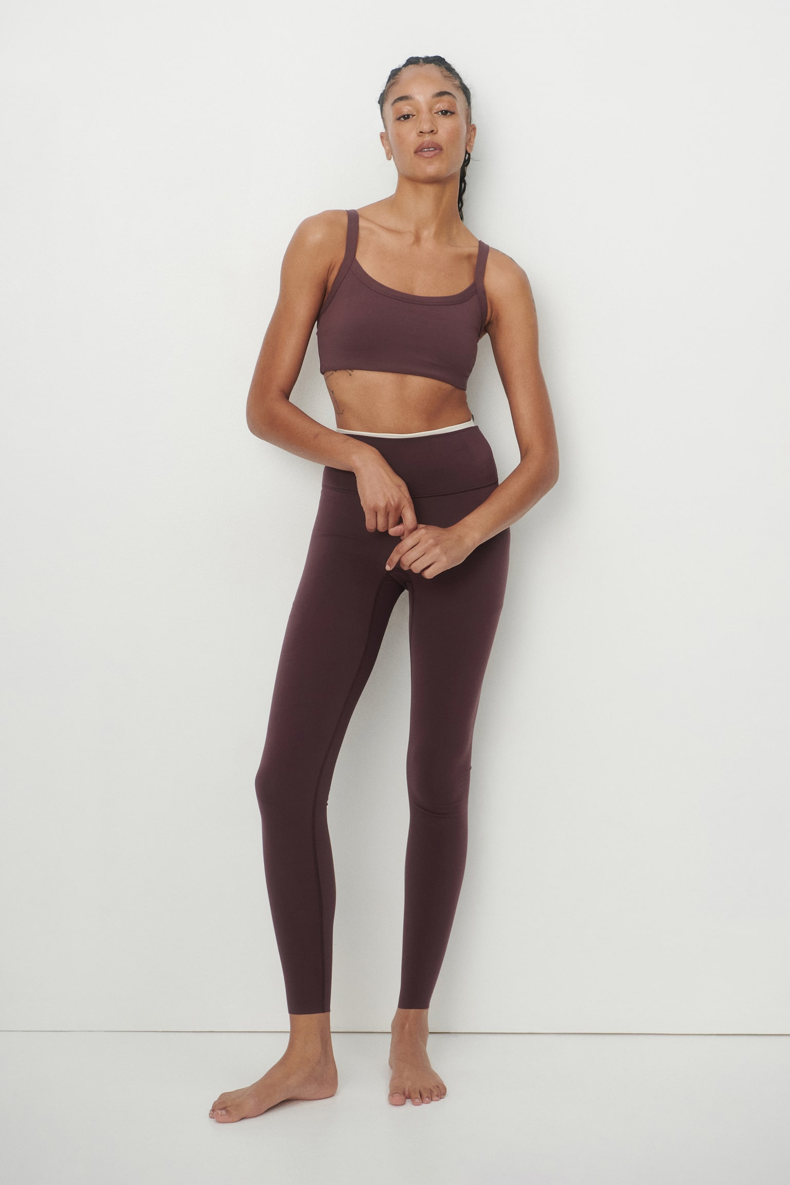 A mauve sports bra featuring a scoop neckline, wide shoulder straps, and subtle seam detailing around the neckline. - 1
