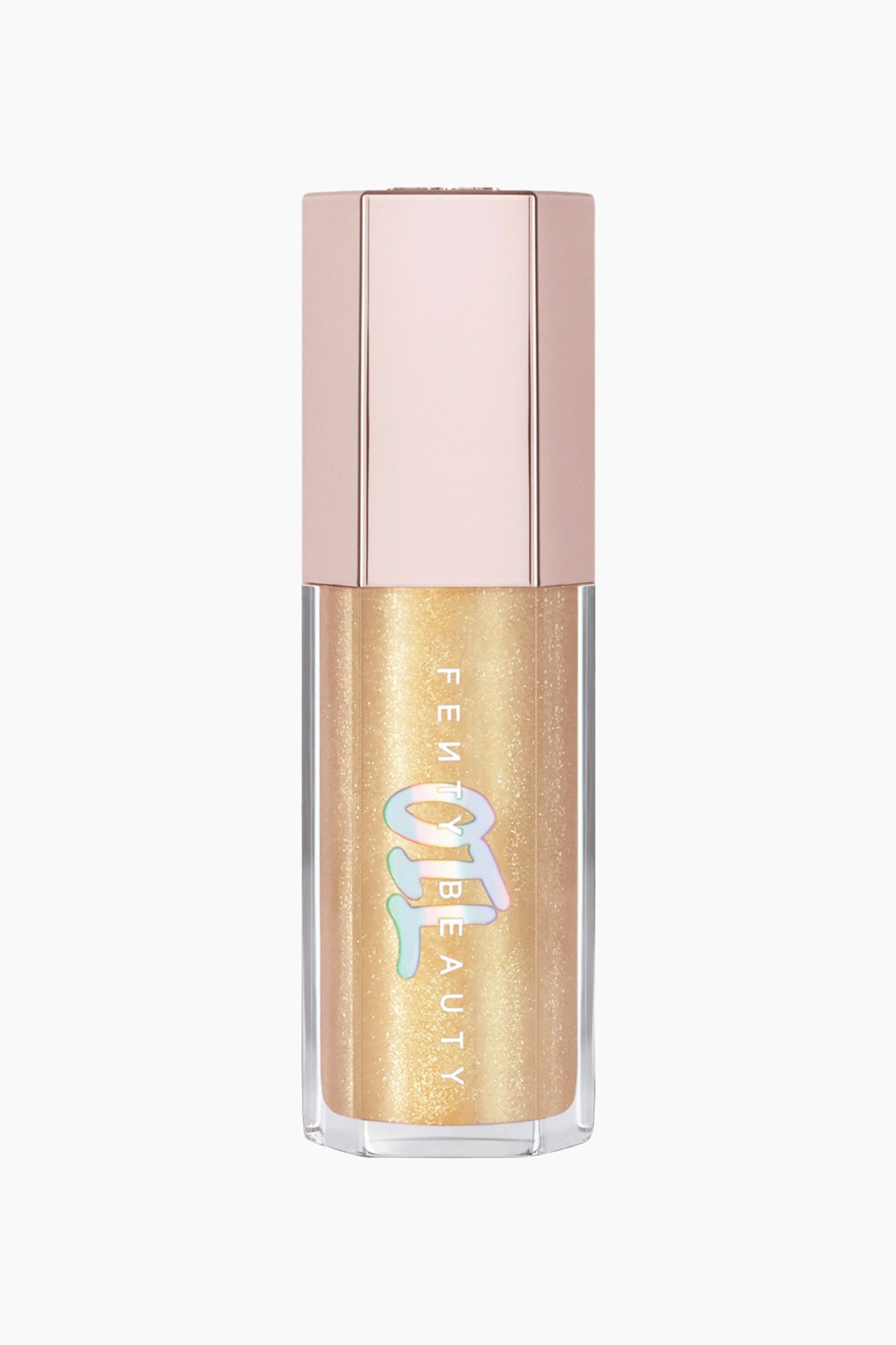 Visa större bild: Gloss Bomb Oil Luminizing Lip Oil 'n Gloss står upprätt i en framåtriktad vy och visar en genomskinlig sexkantig tub fylld med en skimrande guldvätska. Produkten har ett metalliskt ljusrosa sexkantigt lock och vertikal vit ”FENTY BEAUTY”-branding överlagrad med en stor, iriserande holografisk ”OIL”-grafik.
