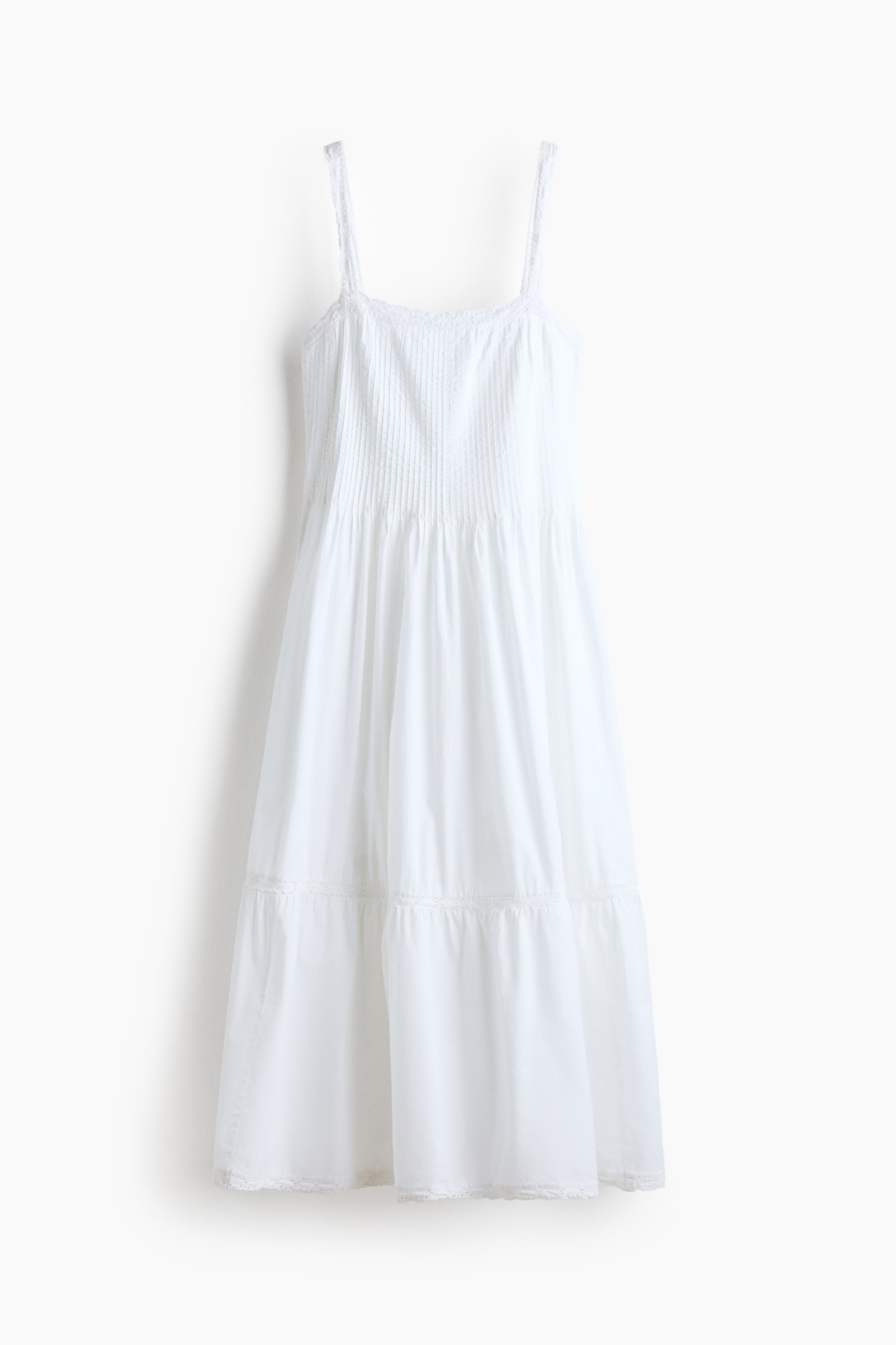 View larger image: A white dress featuring thin shoulder straps and a square neckline. It showcases a pin-tucked bodice, a gathered waist, and a tiered skirt with delicate lace trim along the tiers and hem.