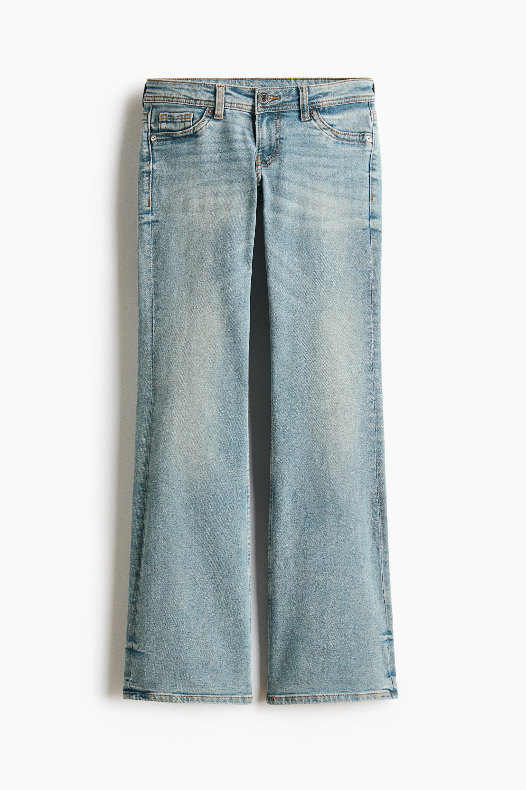 Grotere afbeelding bekijken: Deze lichtgewassen blauwe denim jeans presenteren zich frontaal, met vervaagde gebieden op de bovenbenen. Ze zijn ontworpen met een uitlopende pijp, een knoop- en ritssluiting, en voorzakken met klinknagels.