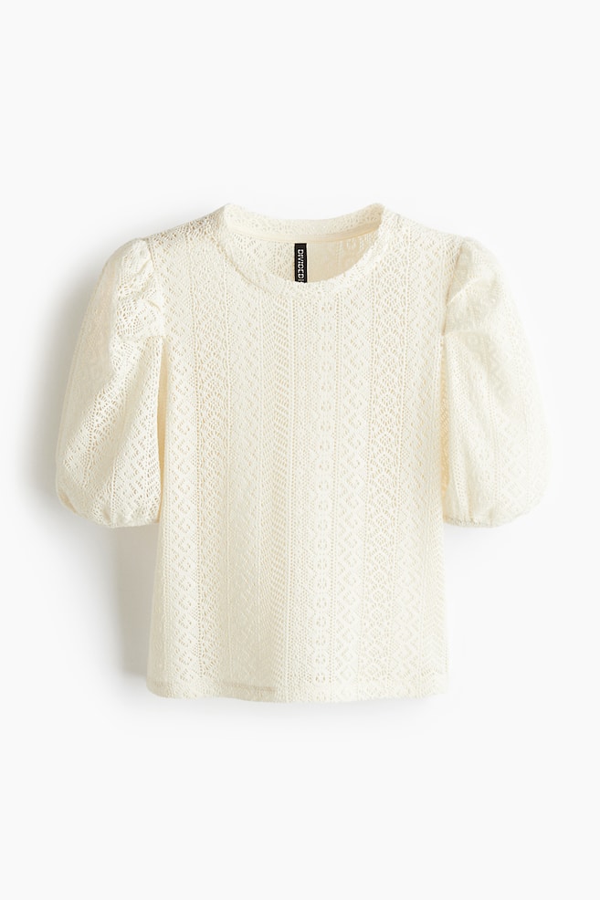 A cream-coloured top is displaying its front view, featuring a soft, lace-look knit with a round neckline and voluminous puff sleeves that are cinching with narrow elastication at the cuffs. - 1