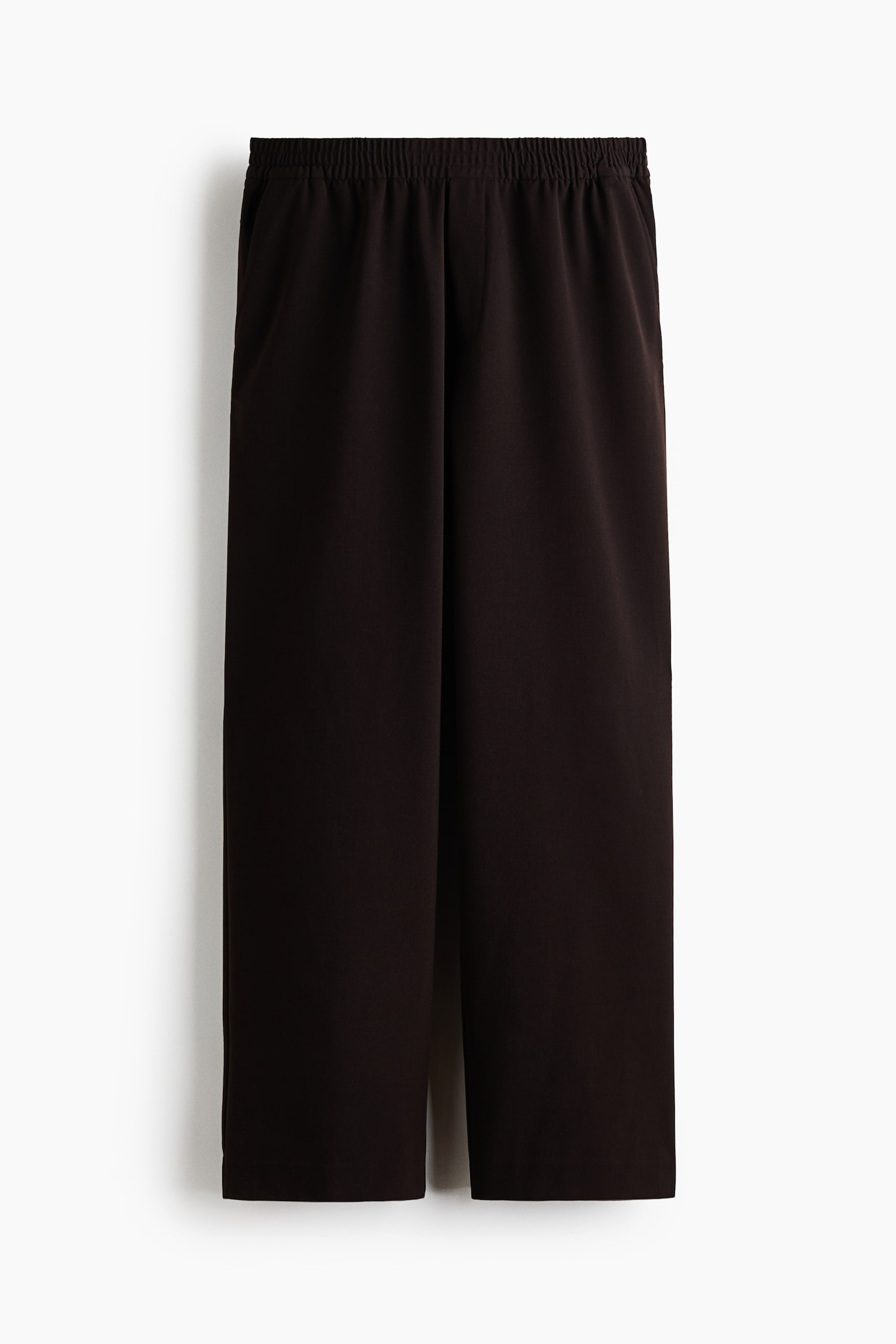 Un paio di pantaloni marrone scuro a gamba larga Ã¨ appeso in una vista frontale, mostrando una vestibilitÃ  morbida e una vita elasticizzata coperta con arricciatura. I pantaloni presentano una finta patta discreta e tasche frontali oblique. - 1