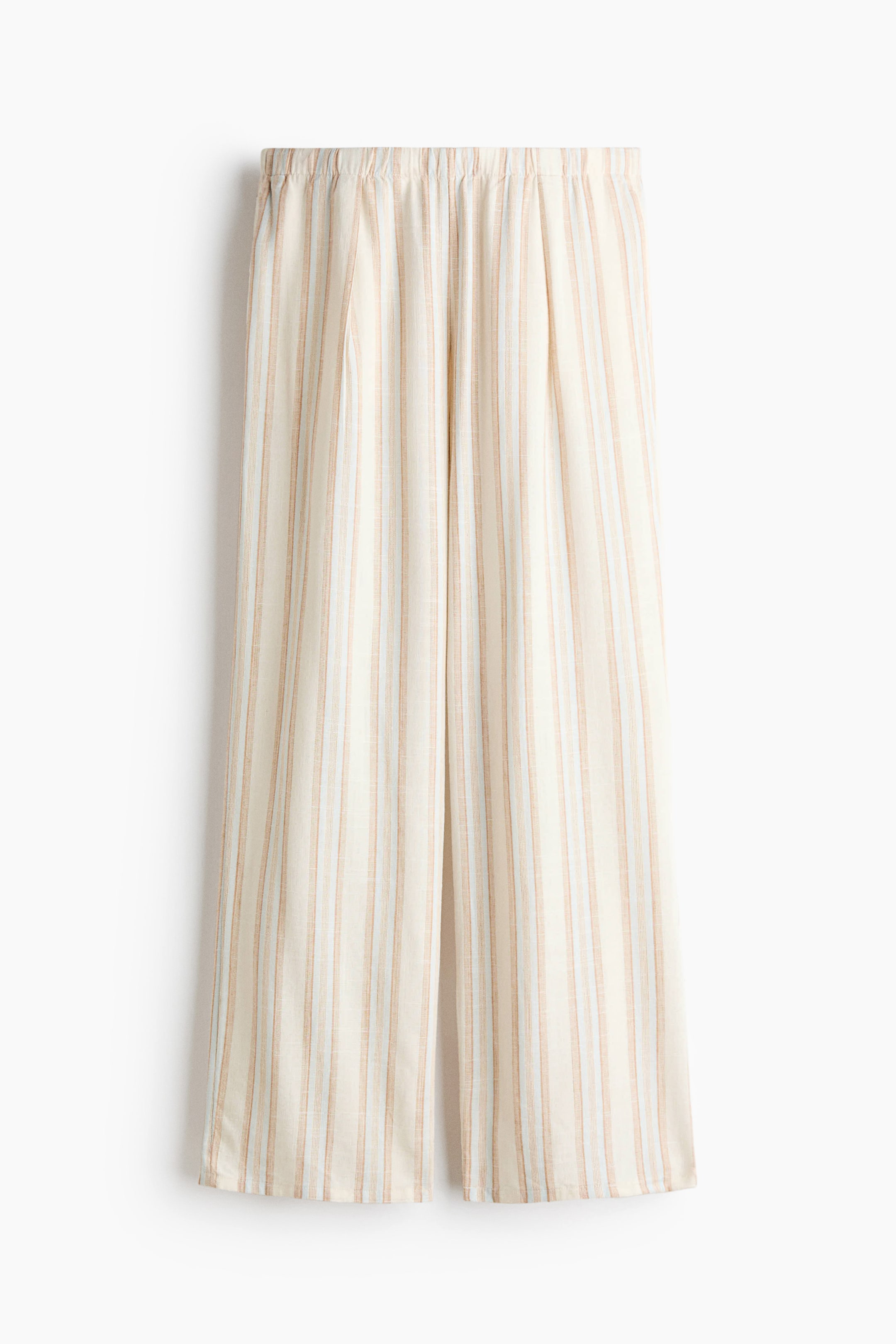 View larger image: The pants are shown from a front perspective, showcasing a cream base adorned with vertical stripes in shades of beige, white, and light blue. They feature an elasticated, gathered waistband and a wide-leg silhouette, with soft pleats cascading from the waist.