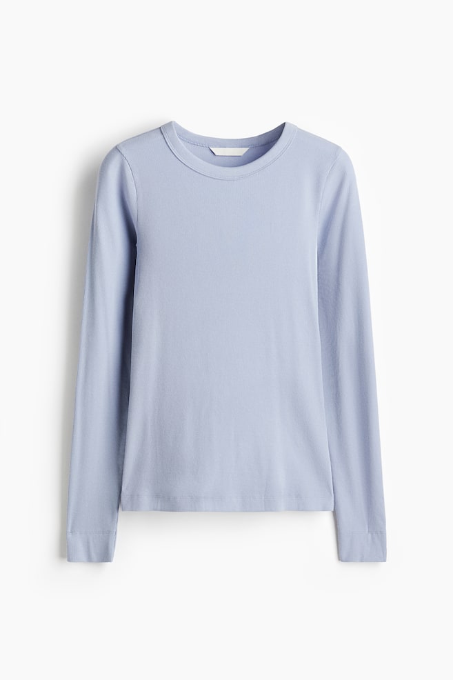 Se presenta una camiseta ajustada de manga larga en color azul claro desde el frente, con un escote redondo y una textura de jersey acanalado. - 1