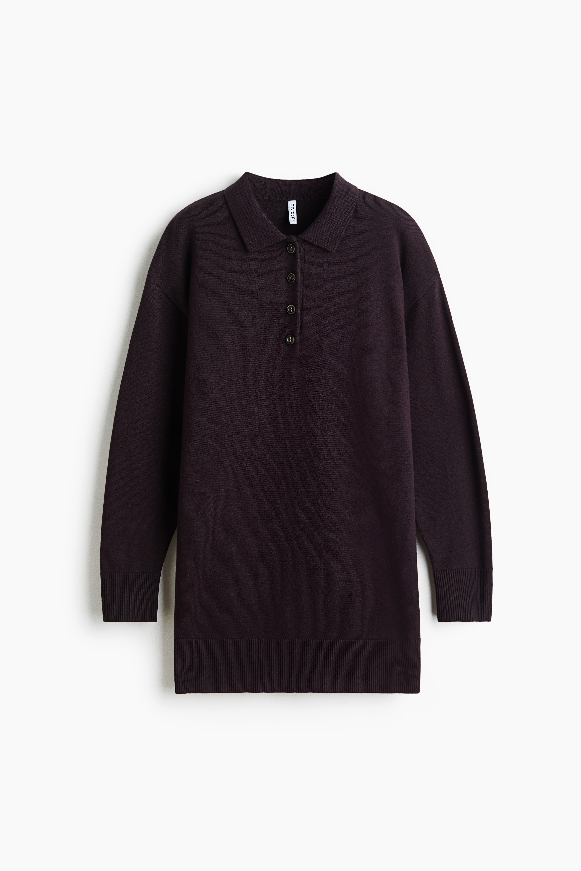A short, dark brown fine-knit dress is shown from the front, featuring a collar, a button placket and a wide ribbed hem. The dress is layered under an open light grey zip-up hoodie, showcasing its relaxed fit and soft texture.