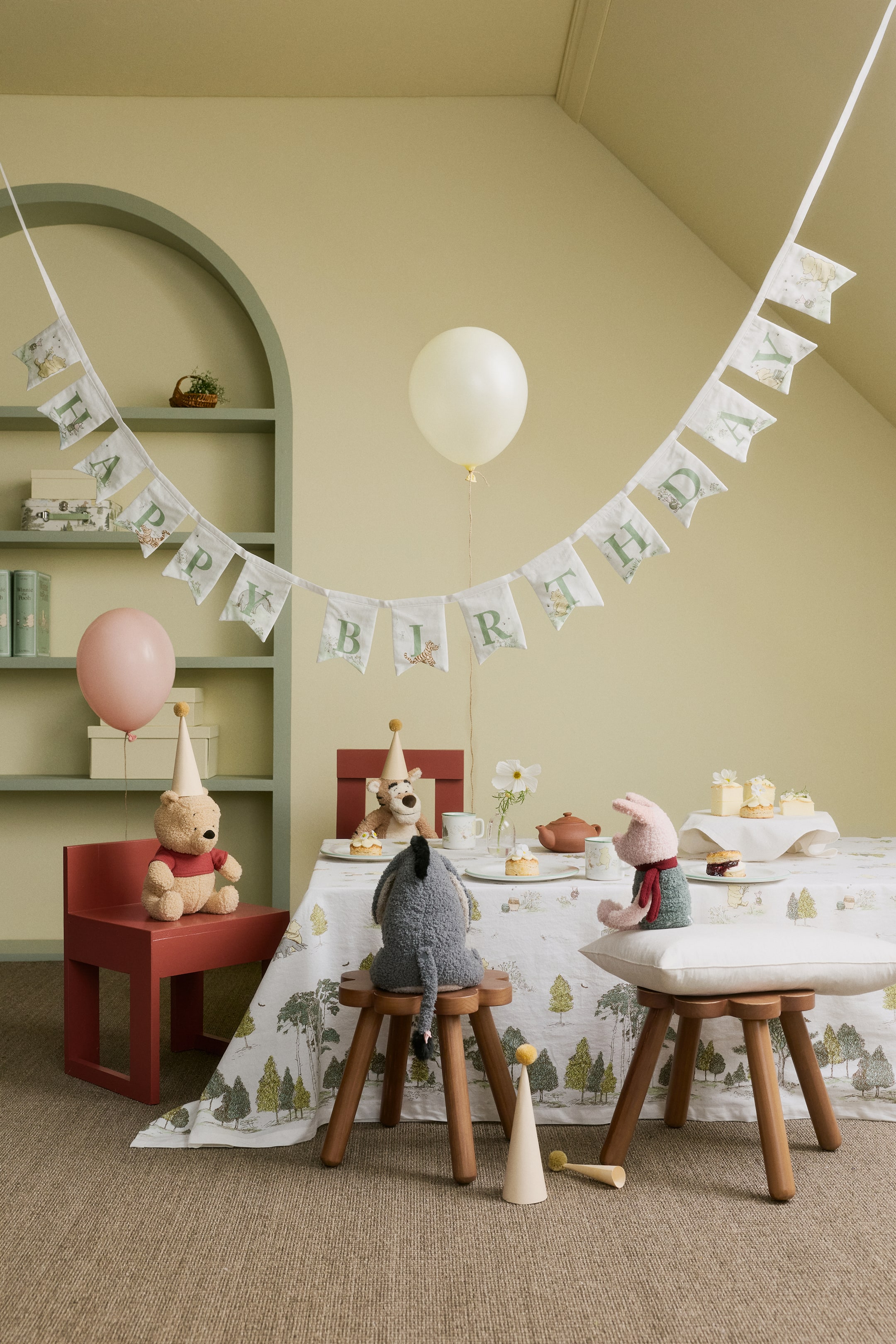 Grotere afbeelding bekijken: Een verjaardagsslinger wordt frontaal gepresenteerd, met witte katoenen geweven vlaggetjes, elk voorzien van een groene letter en kleine karakterprintmotieven, samen goed voor de tekst "HAPPY BIRTHDAY".
