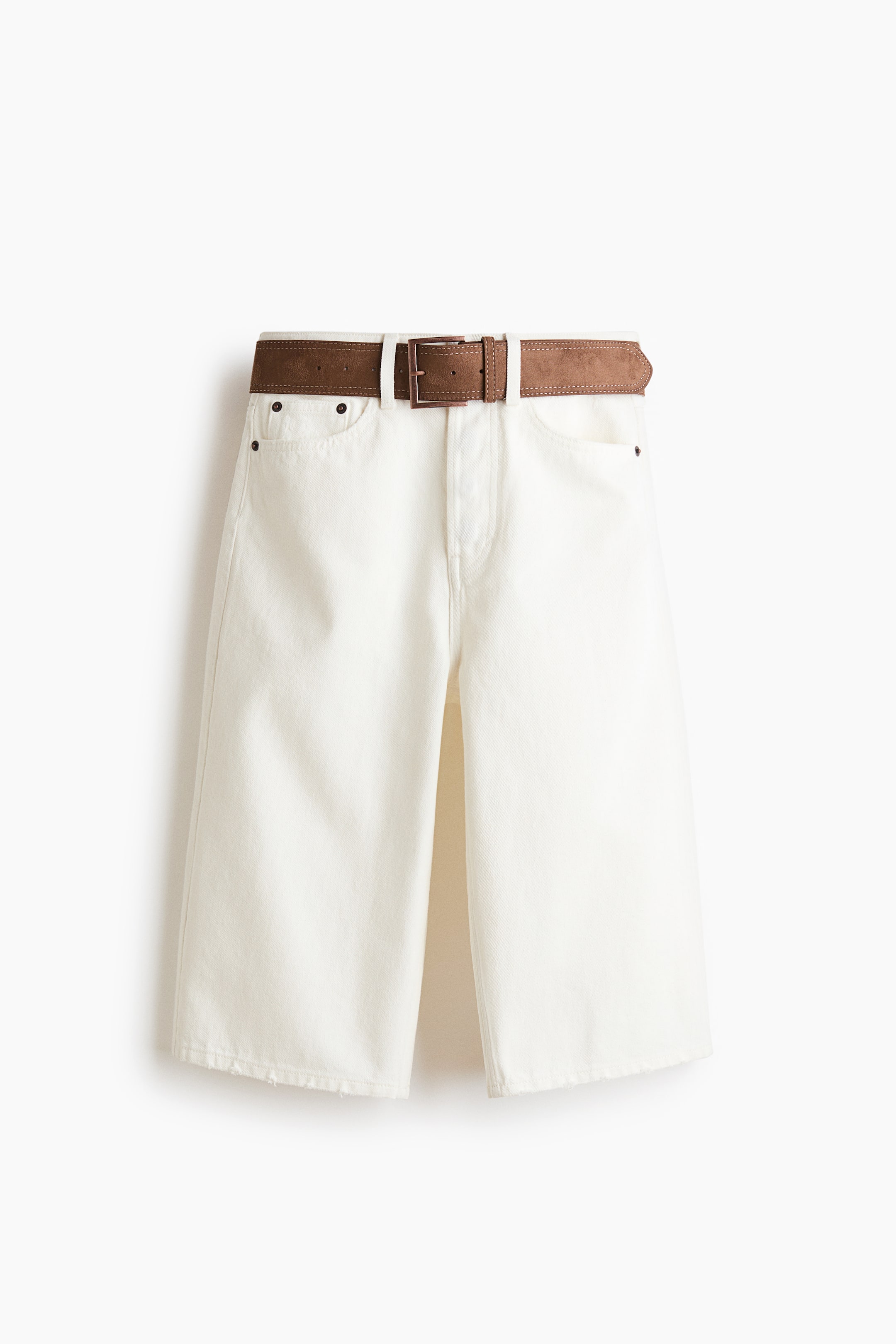 Ver imagen más grande: Pantalones cortos blancos de pierna ancha con dobladillo sin rematar y bolsillos frontales, presentados desde el frente. Un cinturón marrón de imitación ante con una hebilla rectangular oscura está pasado por las trabillas.