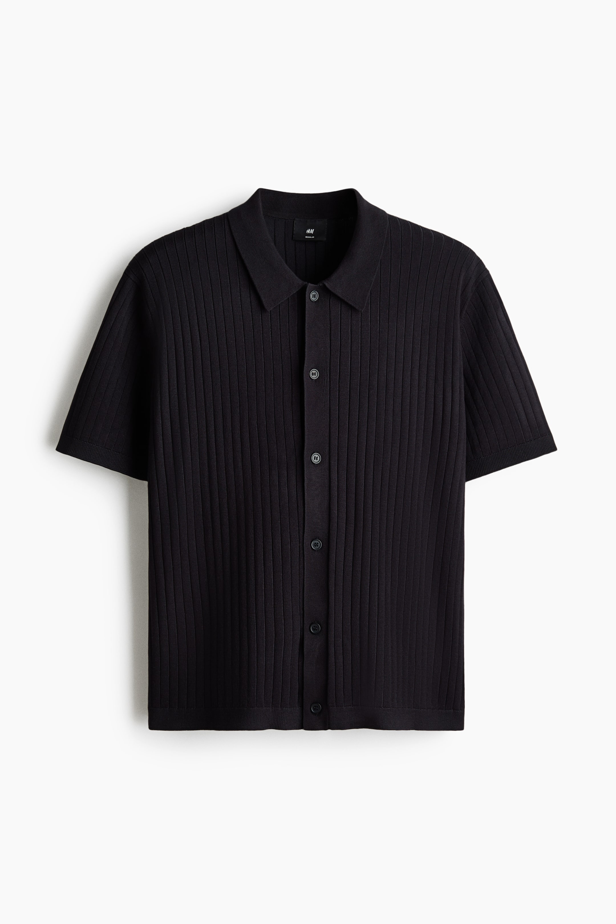 View larger image: A black knit polo shirt is displaying its front, featuring a ribbed texture, a collar, and buttons down the front. It is designed with short sleeves, a straight-cut hem, and a regular fit.