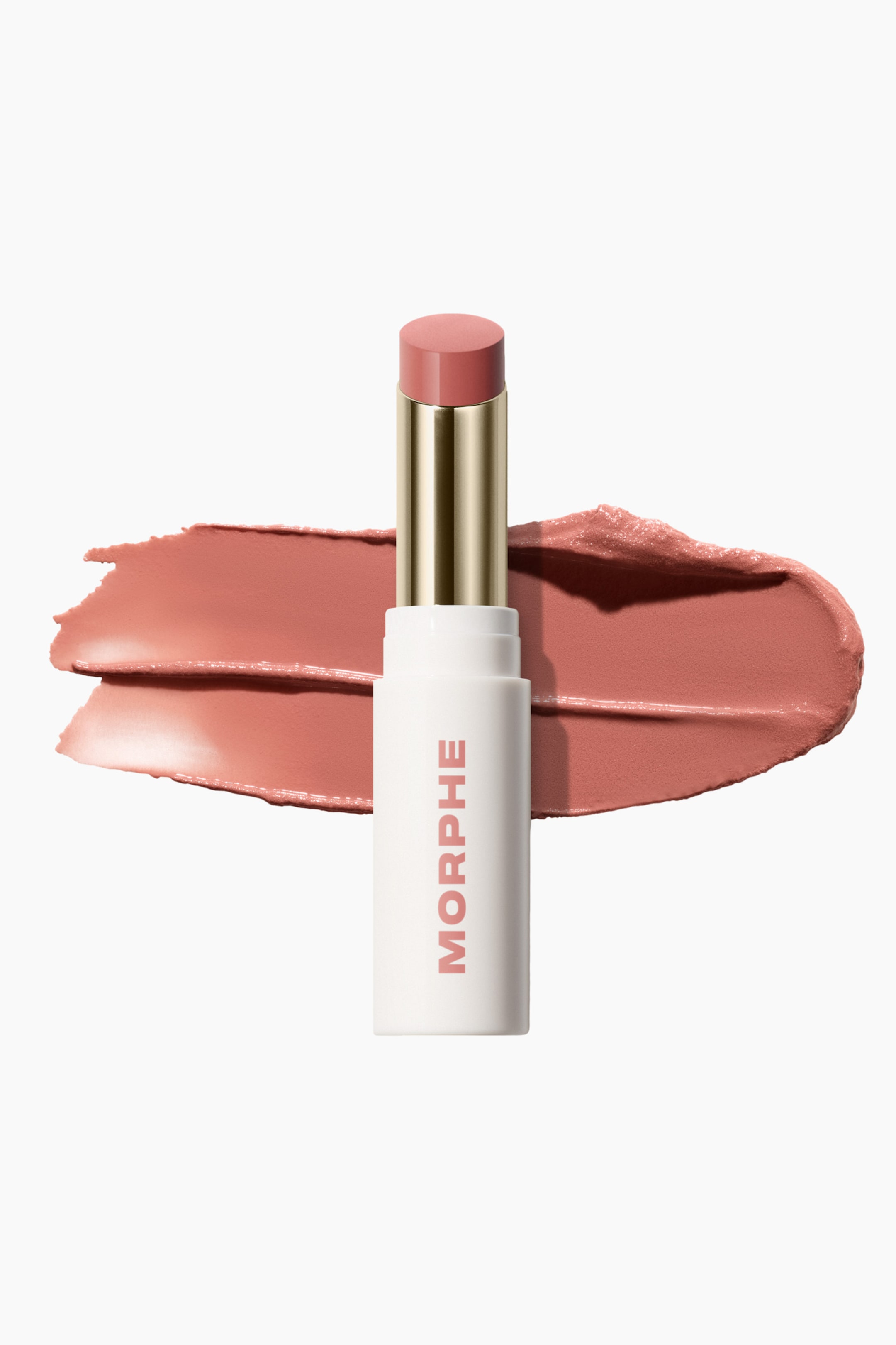 Se større billede: Et Morphe stick-produkt står oprejst, dets hvide hylster prydet med teksten "MORPHE" i en pink-rød farve. En guldfarvet tube er synlig over hylsteret, med den forlængede, afrundede rosenude produktspids fremtrædende, mens to cremede swatches i samme farve vises bagved.